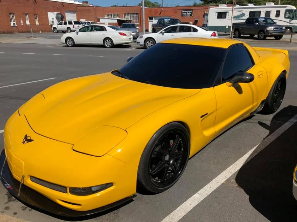 A yellow sports car is parked in a parking lot.