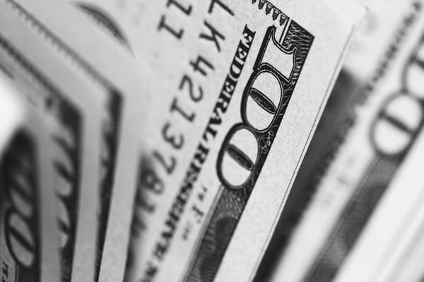 A close up of a stack of 100 dollar bills