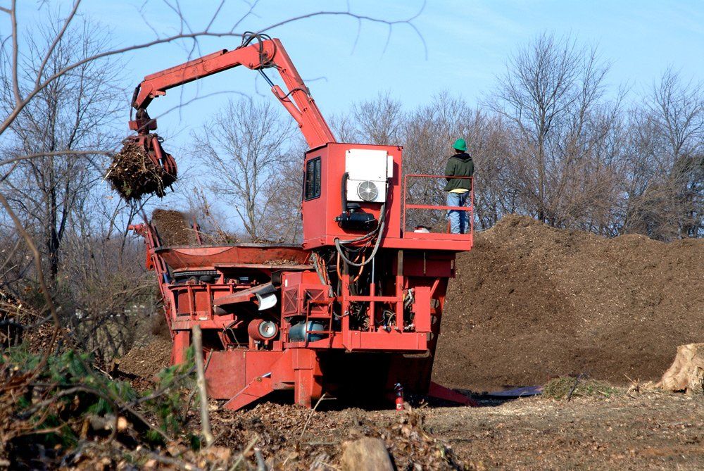Man Working on A Brush Pile Into Mulch — Rutland, MA — Heipt & Sons Forestry Mulching