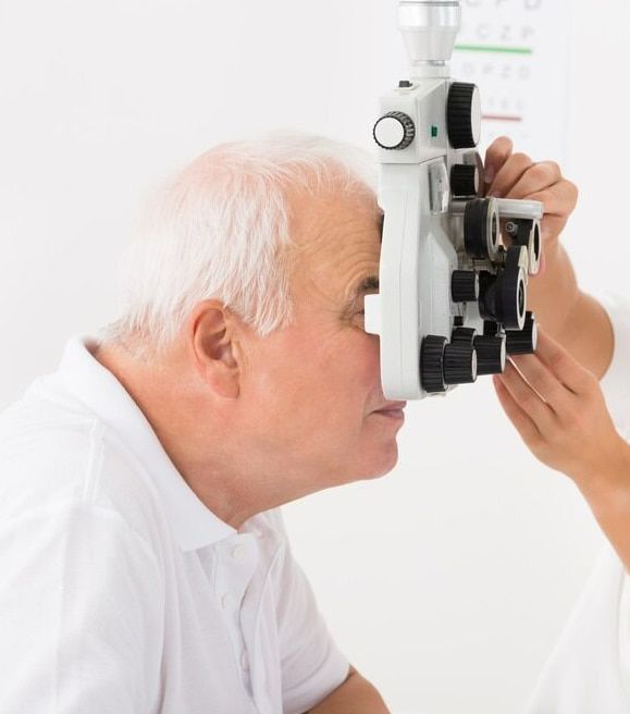 An Older Man is Getting His Eyes Examined by an Ophthalmologist — Ian Emslie Optometrist In Warners Bay, NSW
