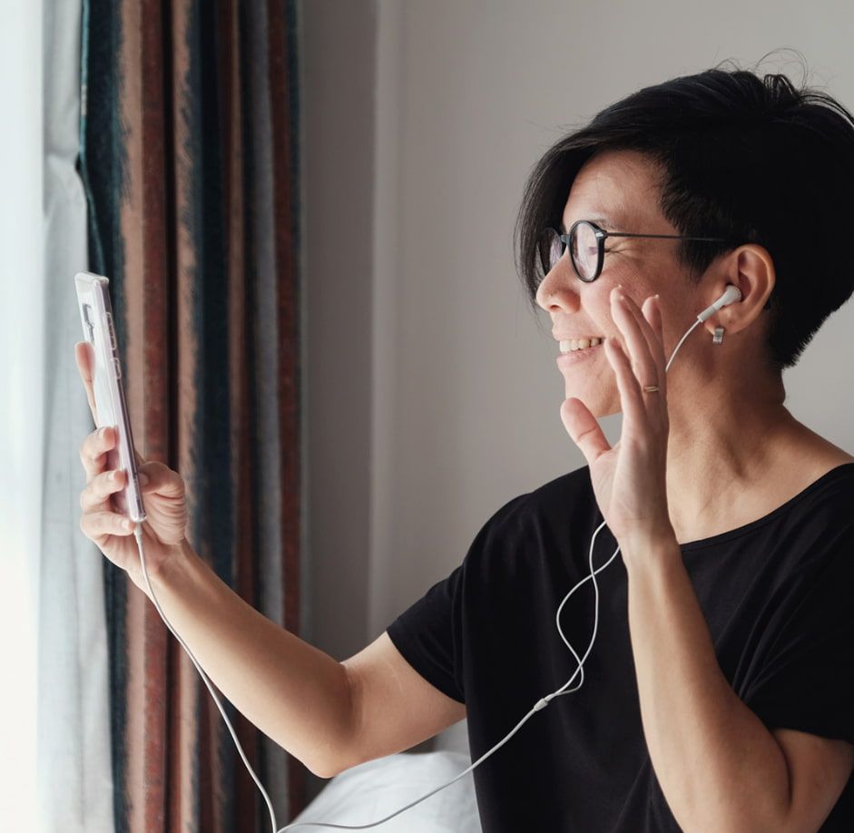 A Woman Wearing Headphones is Taking a Selfie With Her Phone — Ian Emslie Optometrist In Warners Bay, NSW