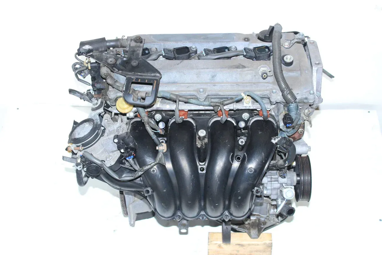 A car engine featuring a prominent black intake manifold, set against a plain white background.