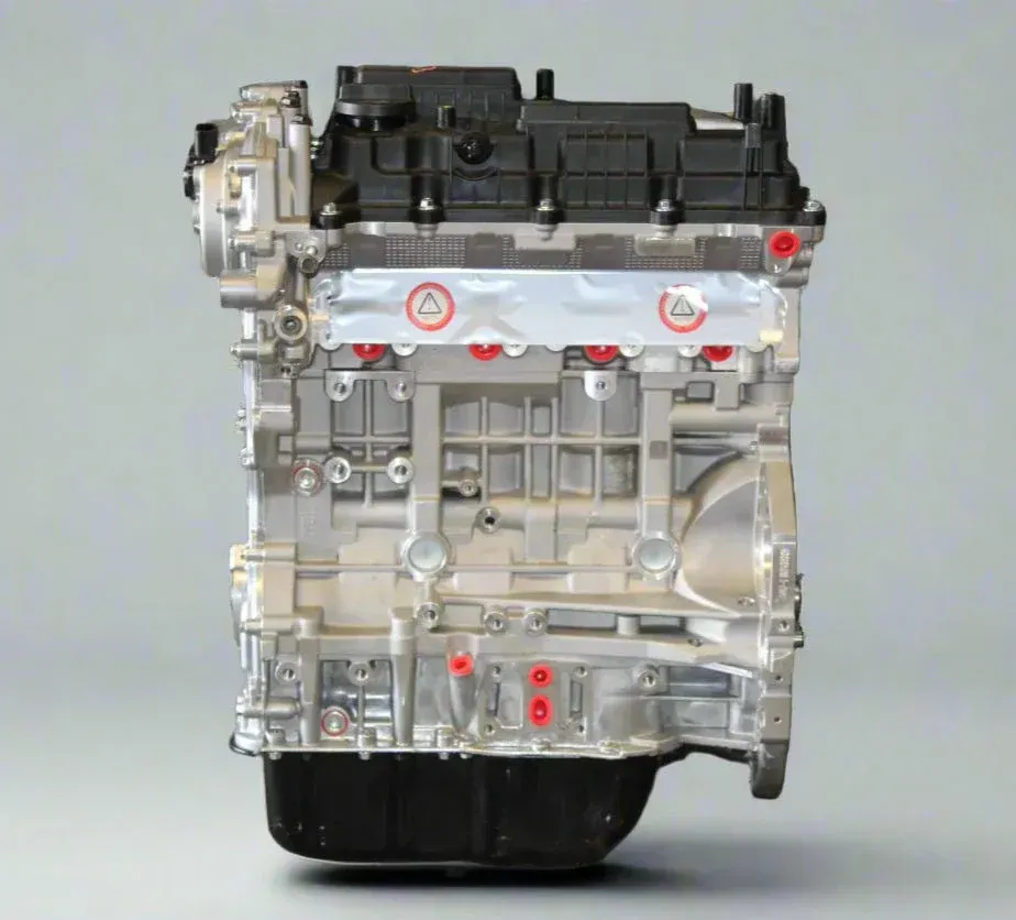 Side view of an internal combustion engine, showing a metal engine block with a black top cover and oil pan.