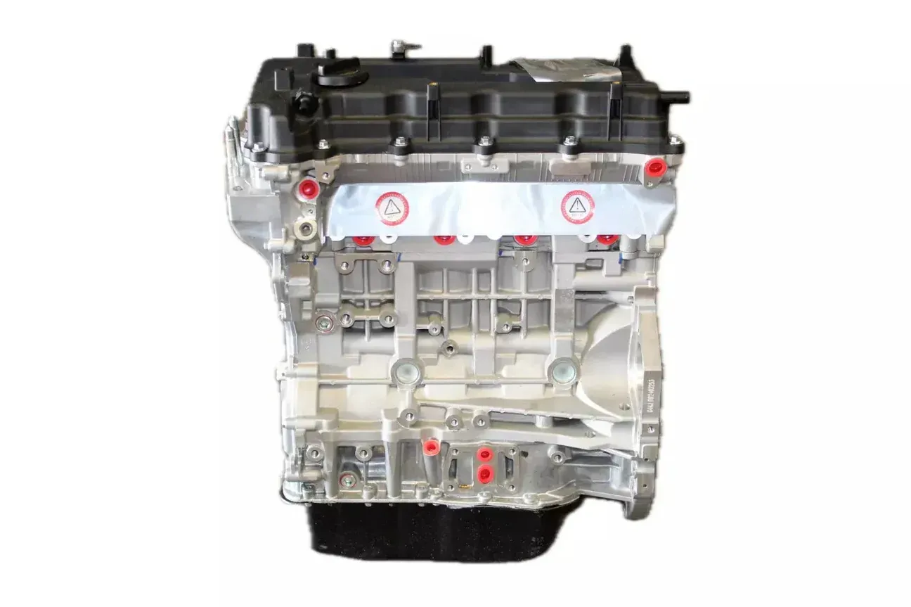 A side view of an automotive engine block with a black valve cover and oil pan against a plain white background.