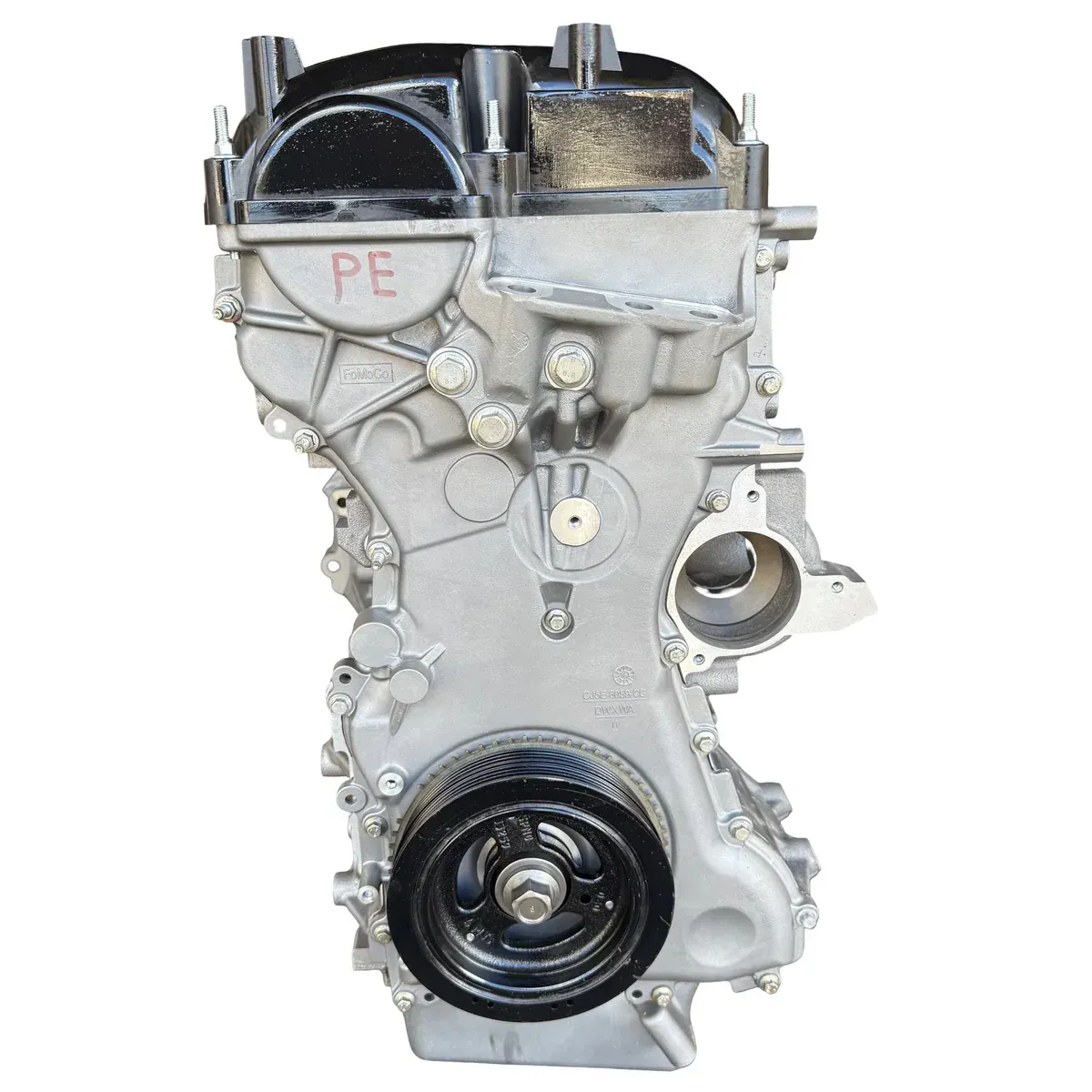 A silver-colored, four-cylinder automotive engine block assembly shown from a side angle, featuring a pulley wheel.