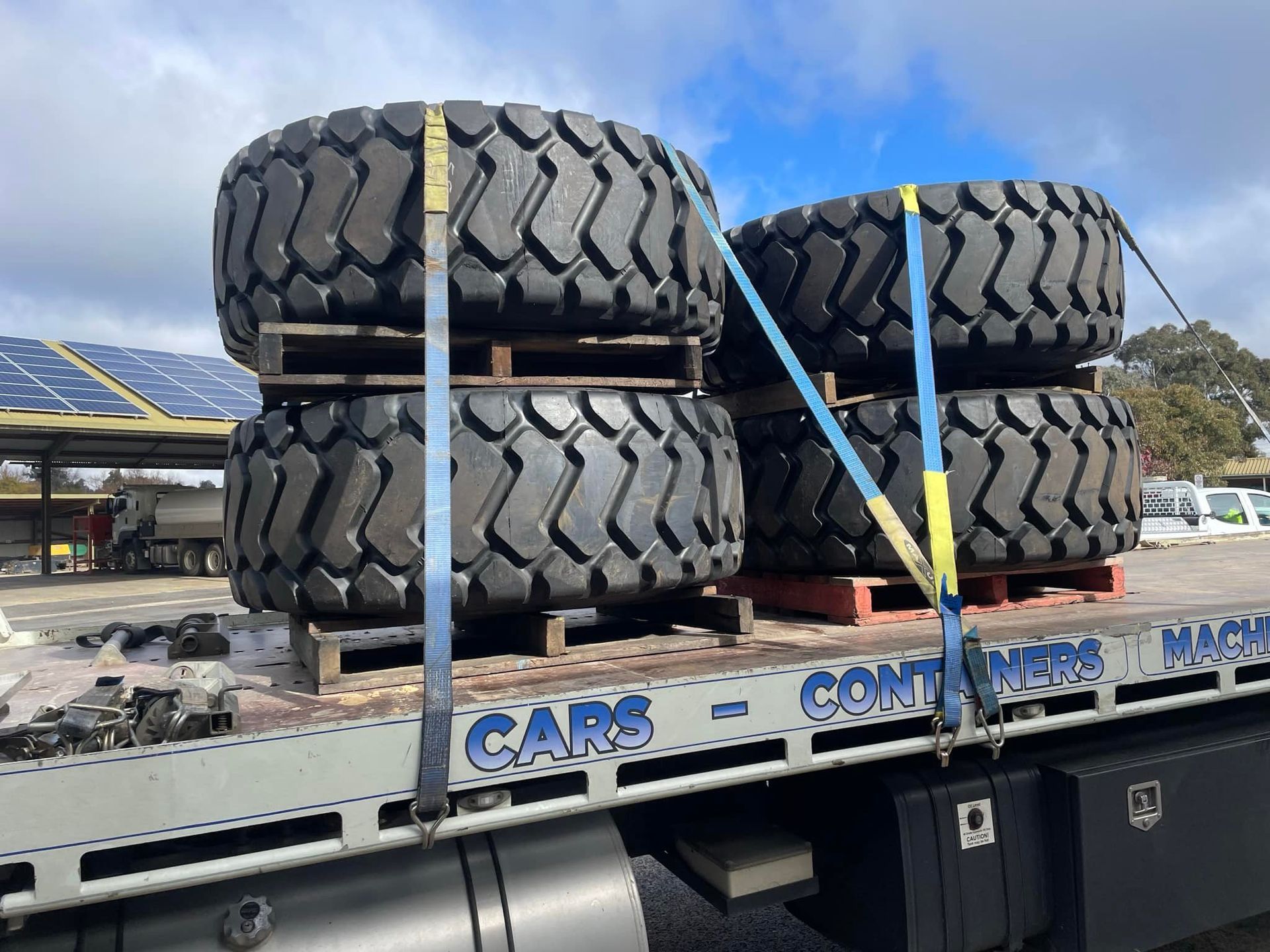 Four tires are stacked on top of each other on a flatbed truck.