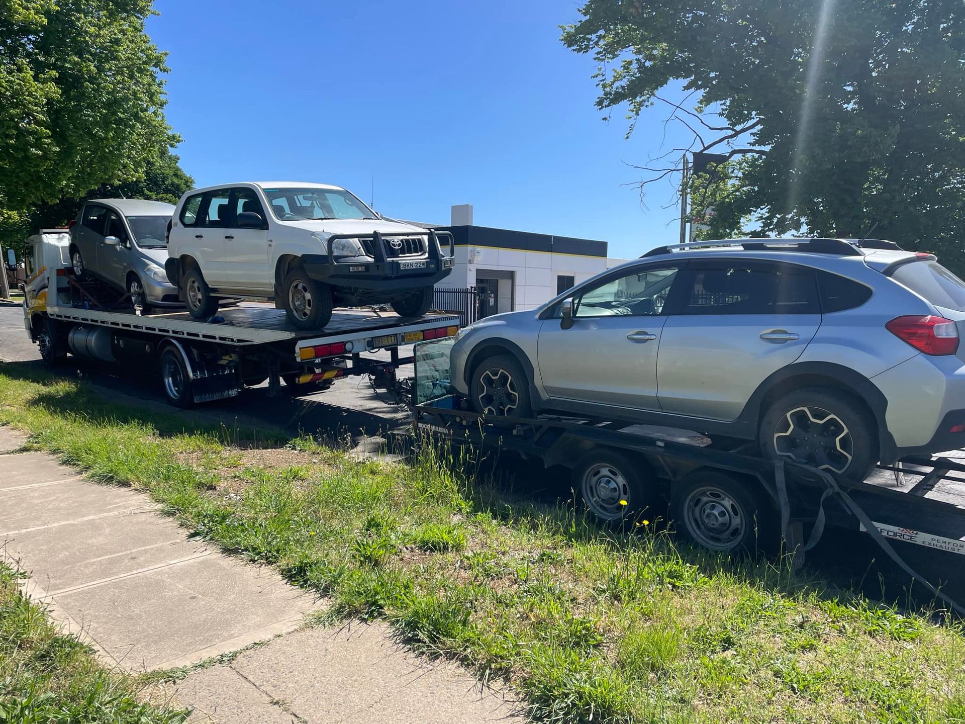 A silver suv is being towed by a tow truck.
