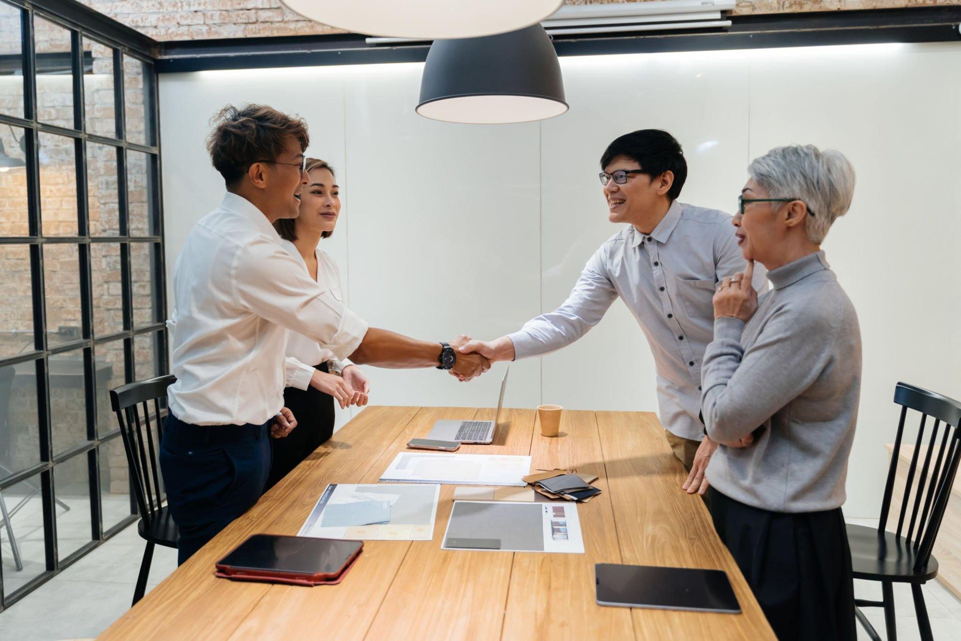 A group of people are shaking hands in a conference room.