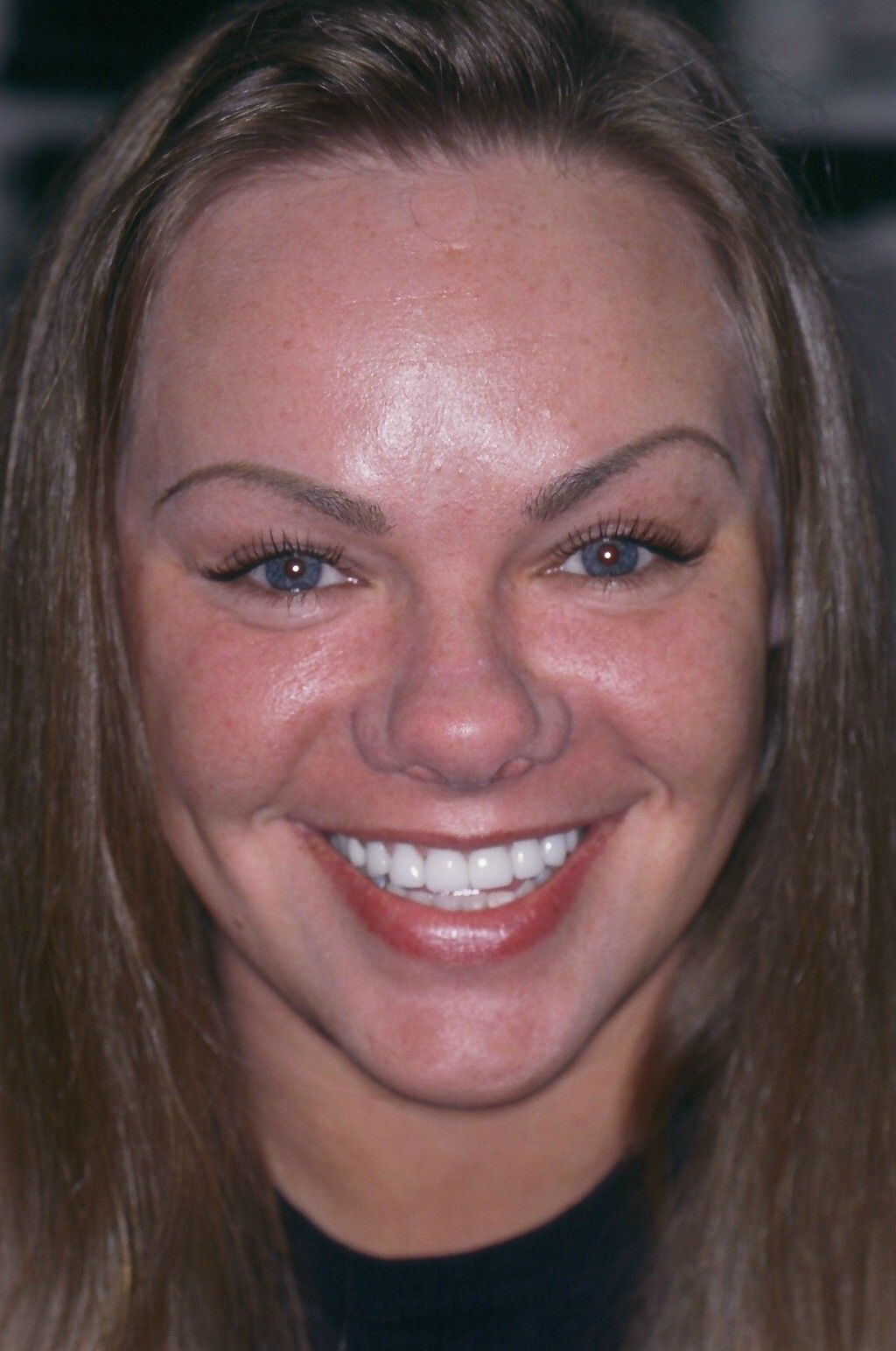 A close up of a woman 's face with a smile on her face.