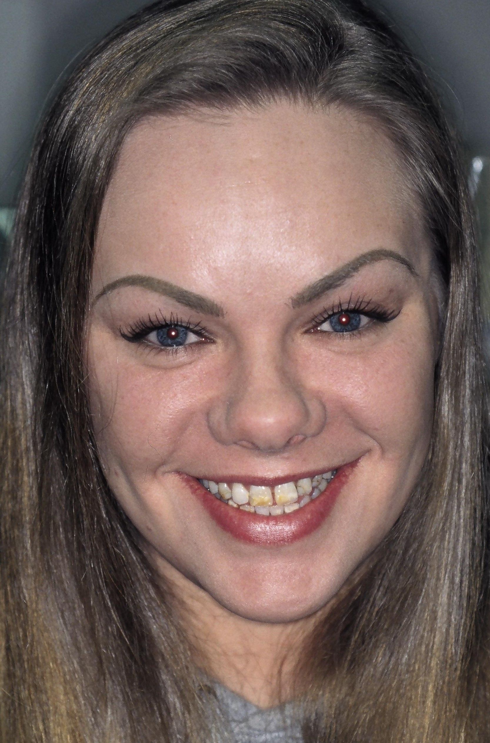 A close up of a woman 's face smiling.