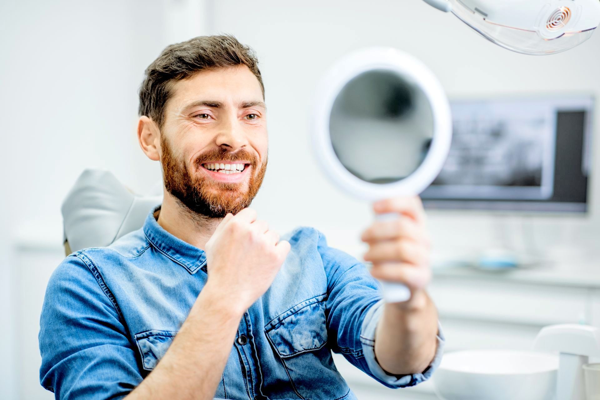 man smiling in mirror | Cosmetic dentist in Hunt Valley MD
