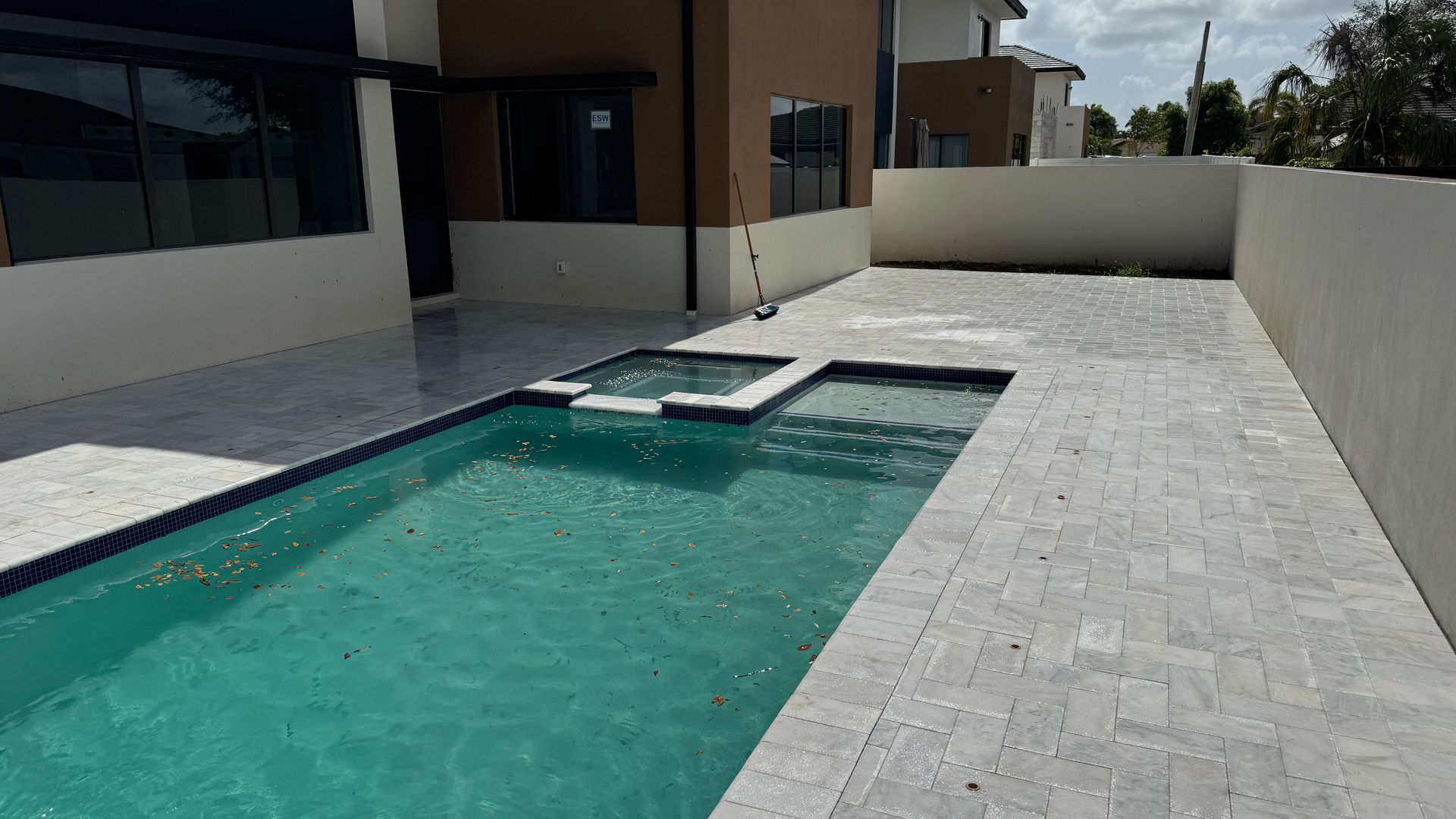 A set of stairs with a stainless steel railing surrounded by bushes.