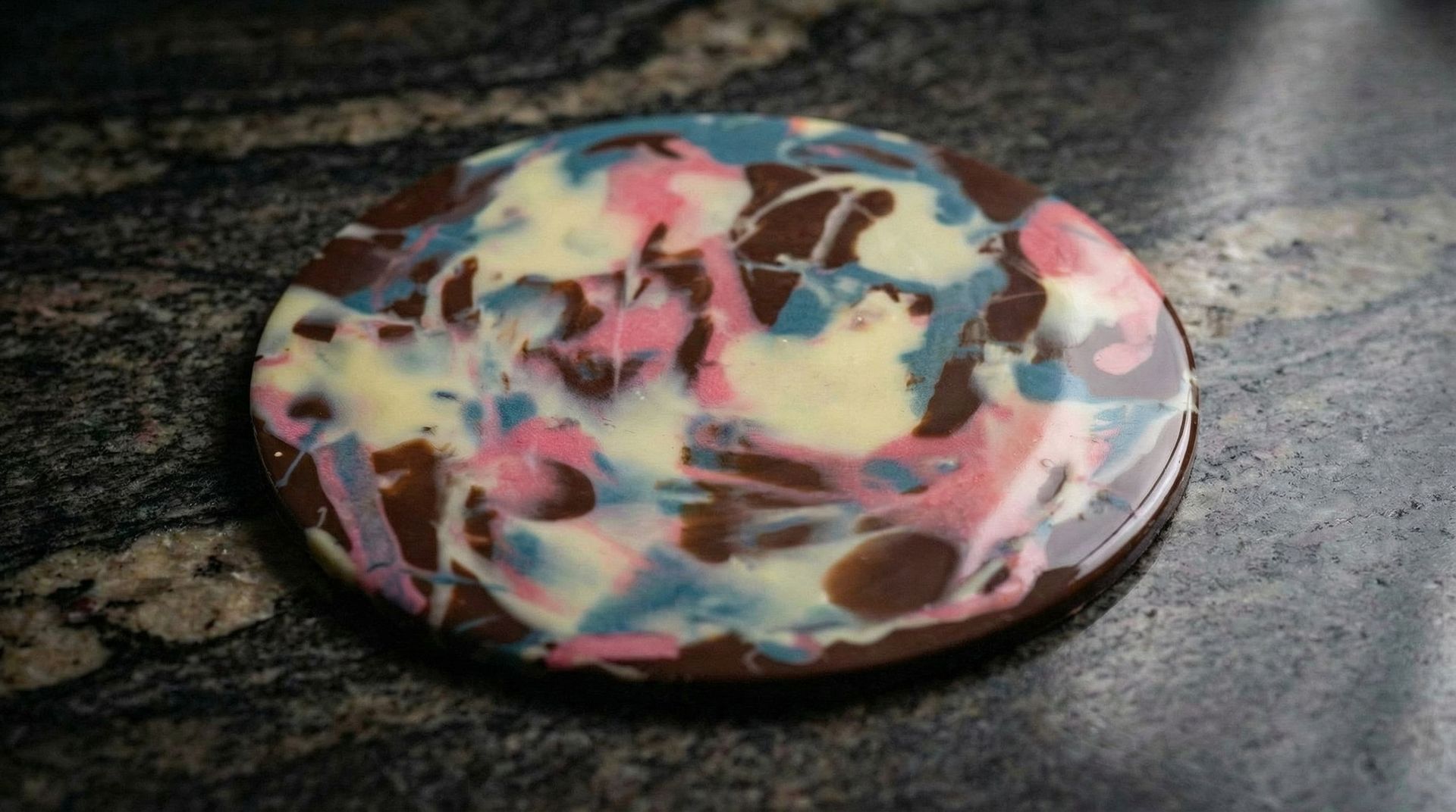 Artistic chocolate disk with colored cocoa butter