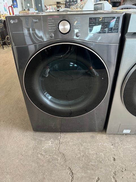 A washer and dryer are sitting next to each other on the floor.