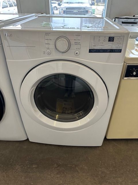 A white washer and dryer are sitting next to each other on a concrete floor.