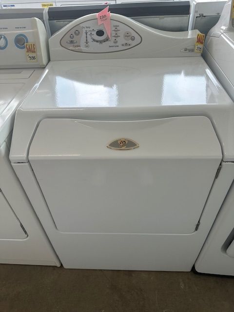 A white dryer is sitting on top of a white washer and dryer.