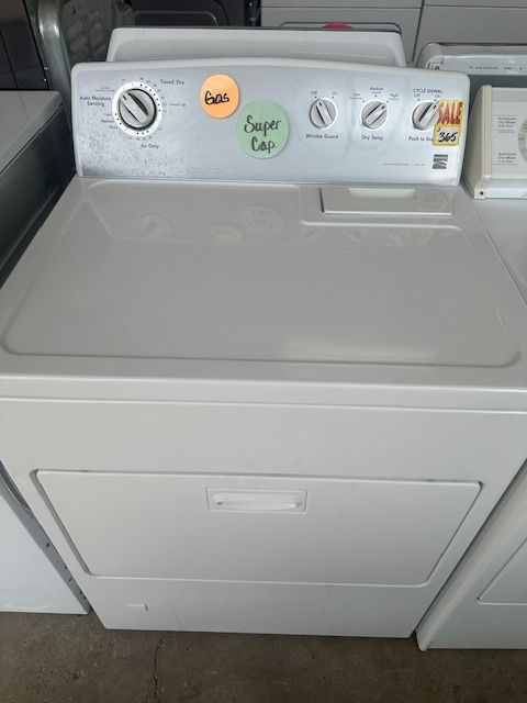 A white washer and dryer are sitting next to each other in a room.