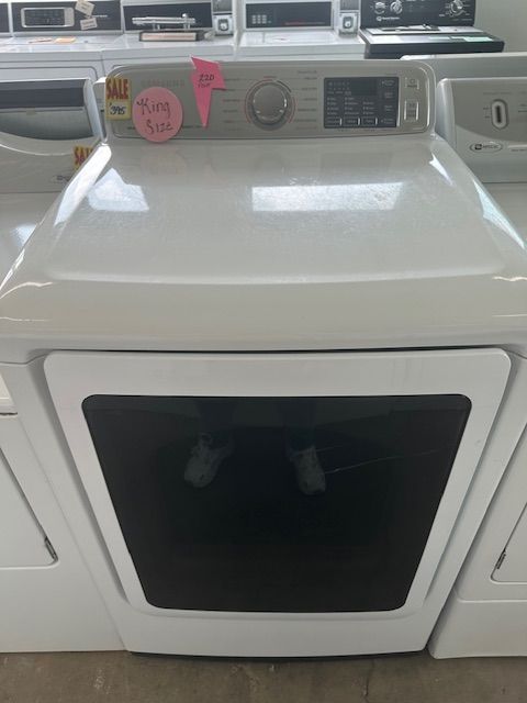 A white washer and dryer are sitting on top of each other in a laundromat.