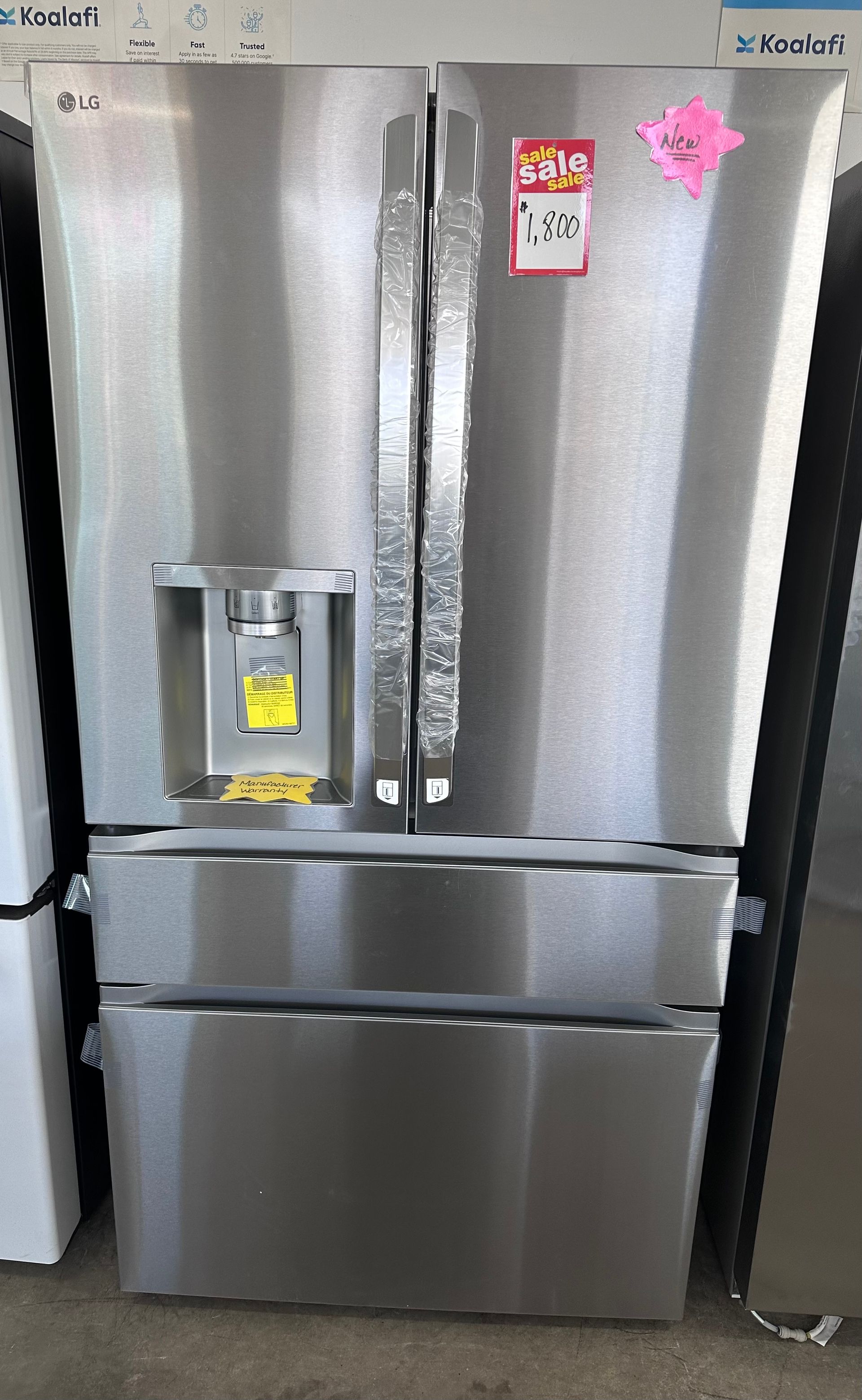 A stainless steel French door refrigerator with an external water and ice dispenser, featuring two pull-out freezer drawers.