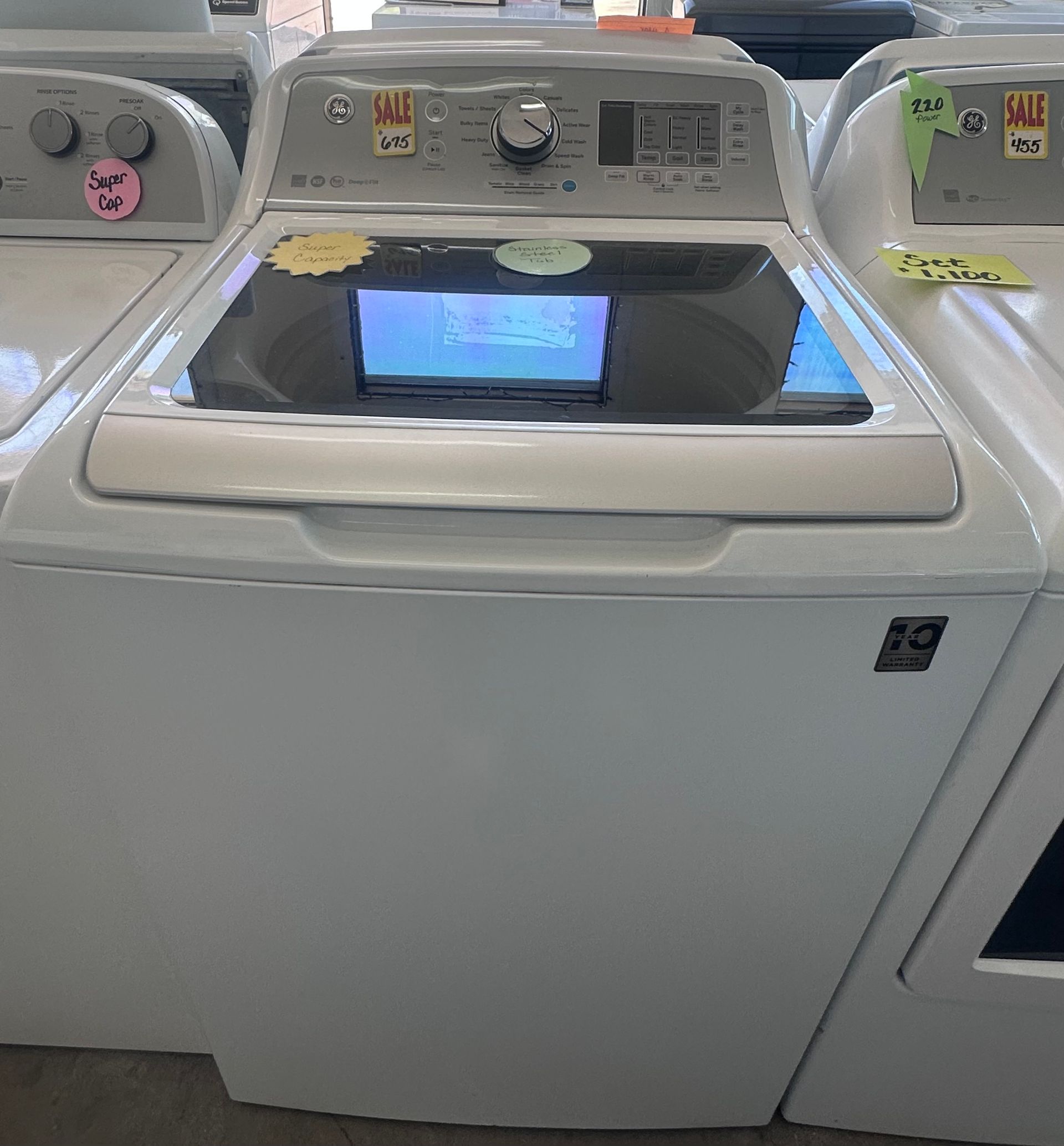 White GE top-load washing machine with controls on the top panel.