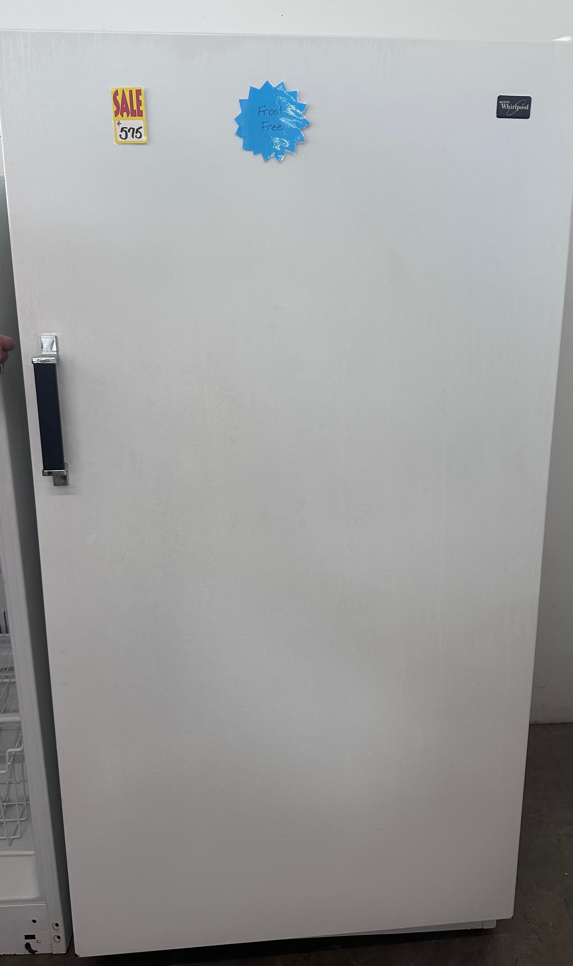 A white refrigerator with a blue sticker on the door.