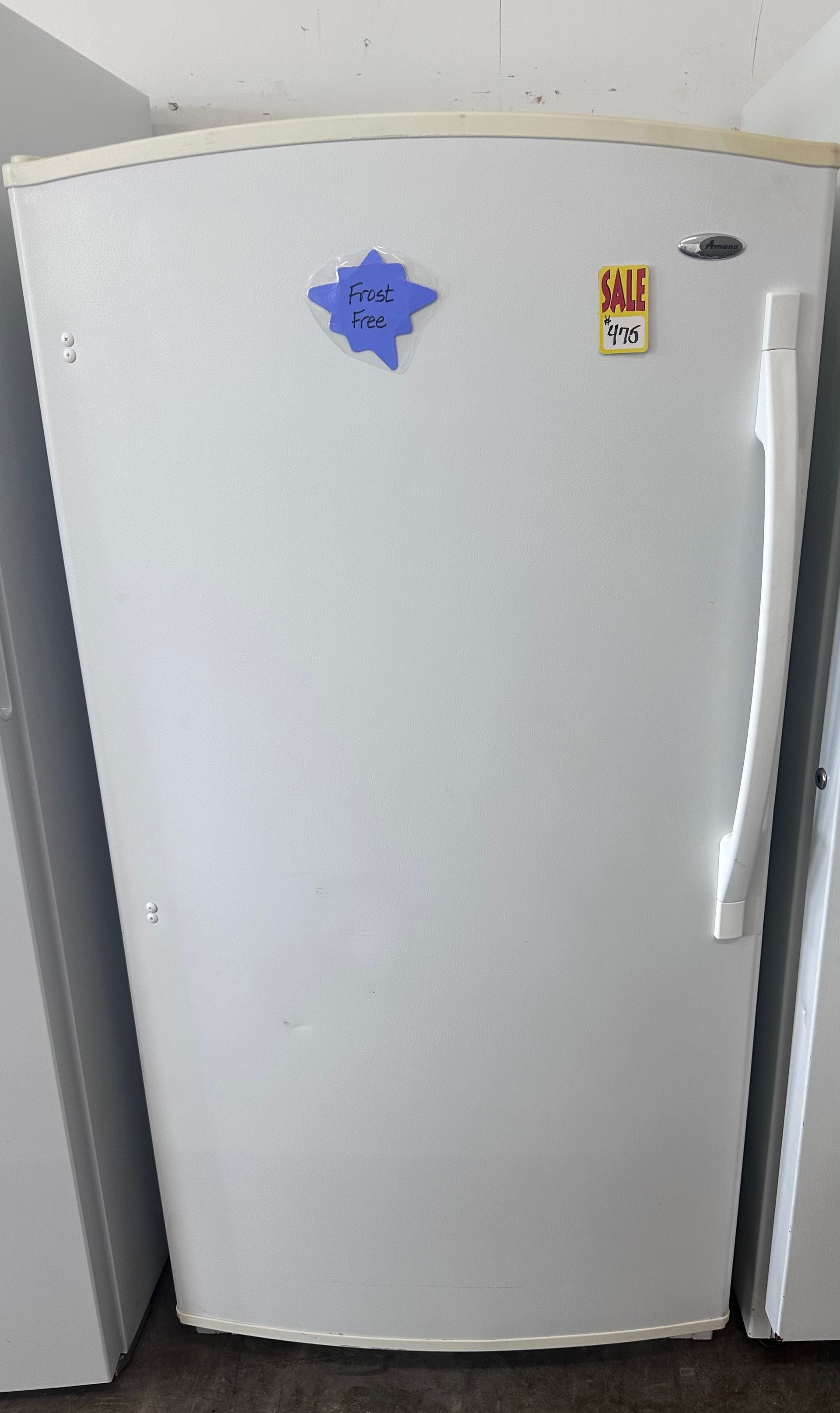A white refrigerator with a blue sticker on the door.