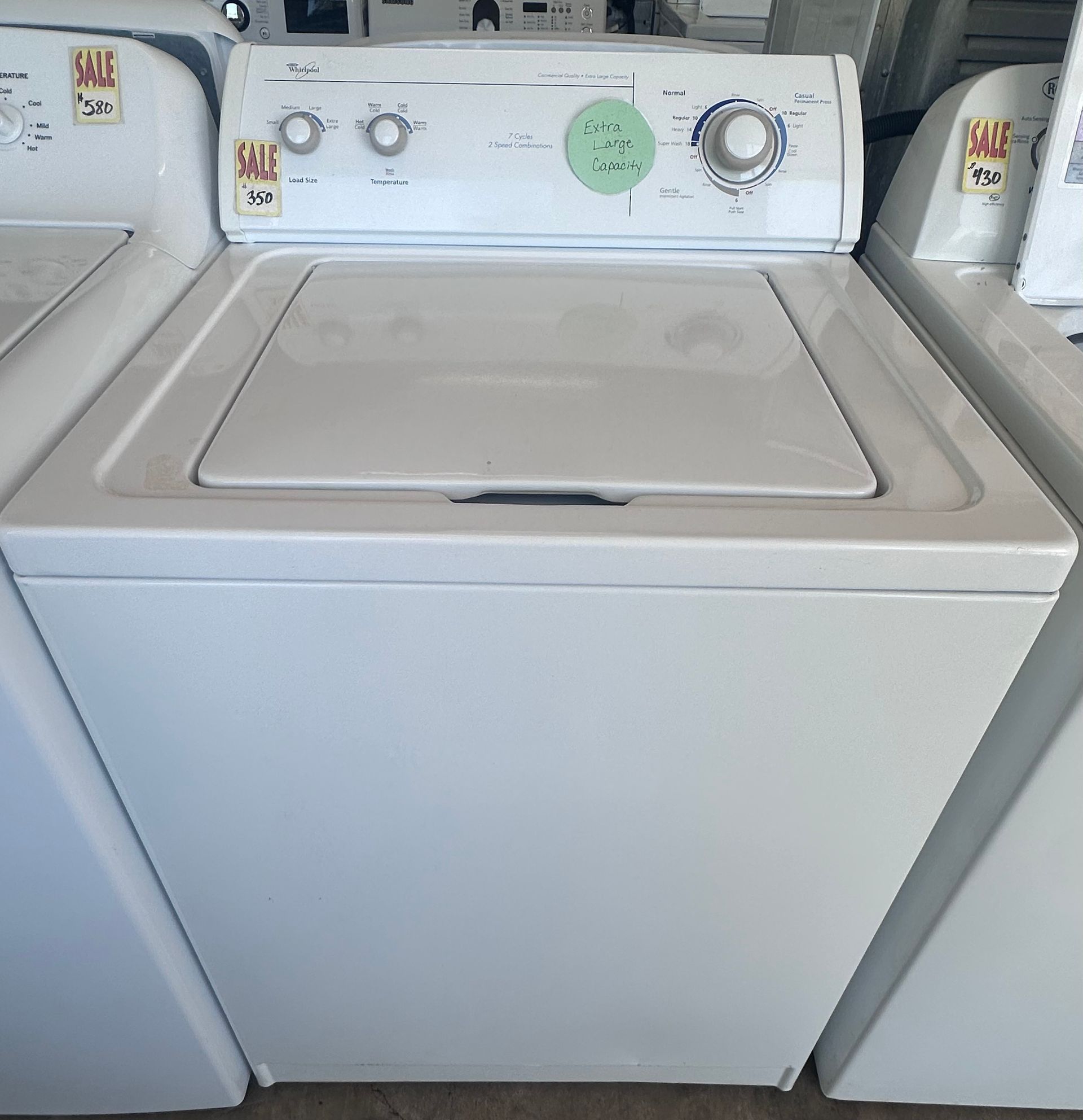A stainless steel washing machine with a black door
