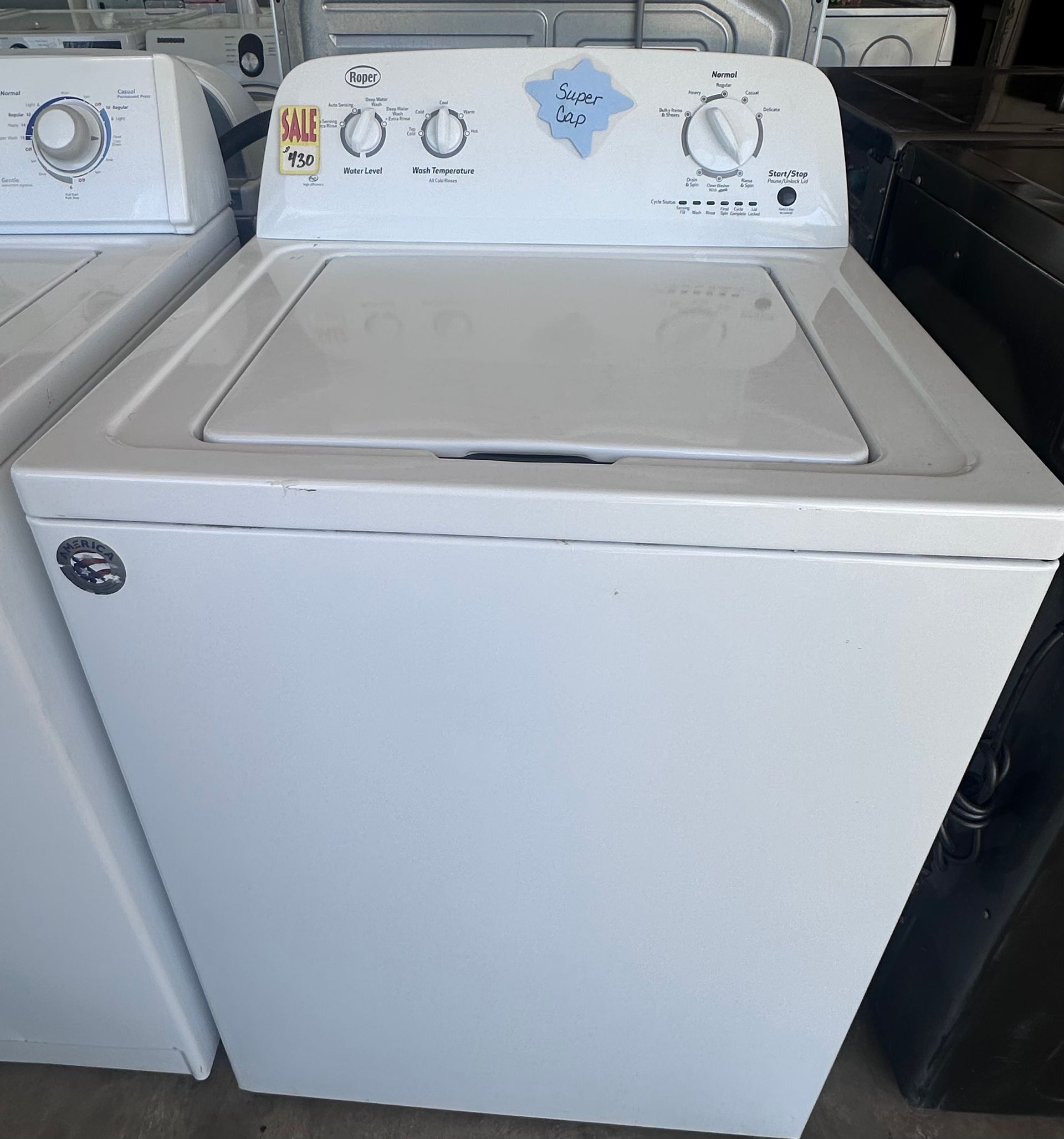 A stainless steel washing machine with a black door