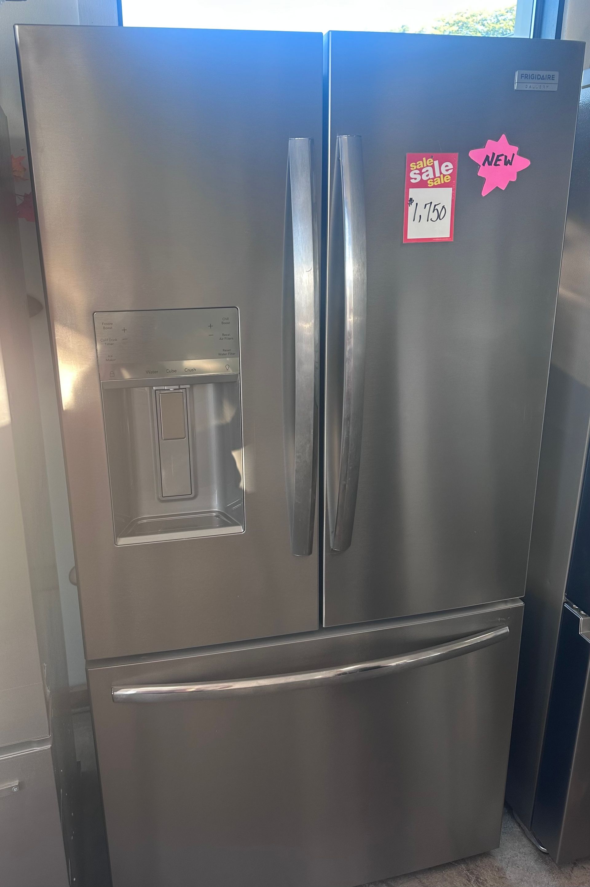 Stainless steel French door refrigerator with a water dispenser and a bottom freezer.
