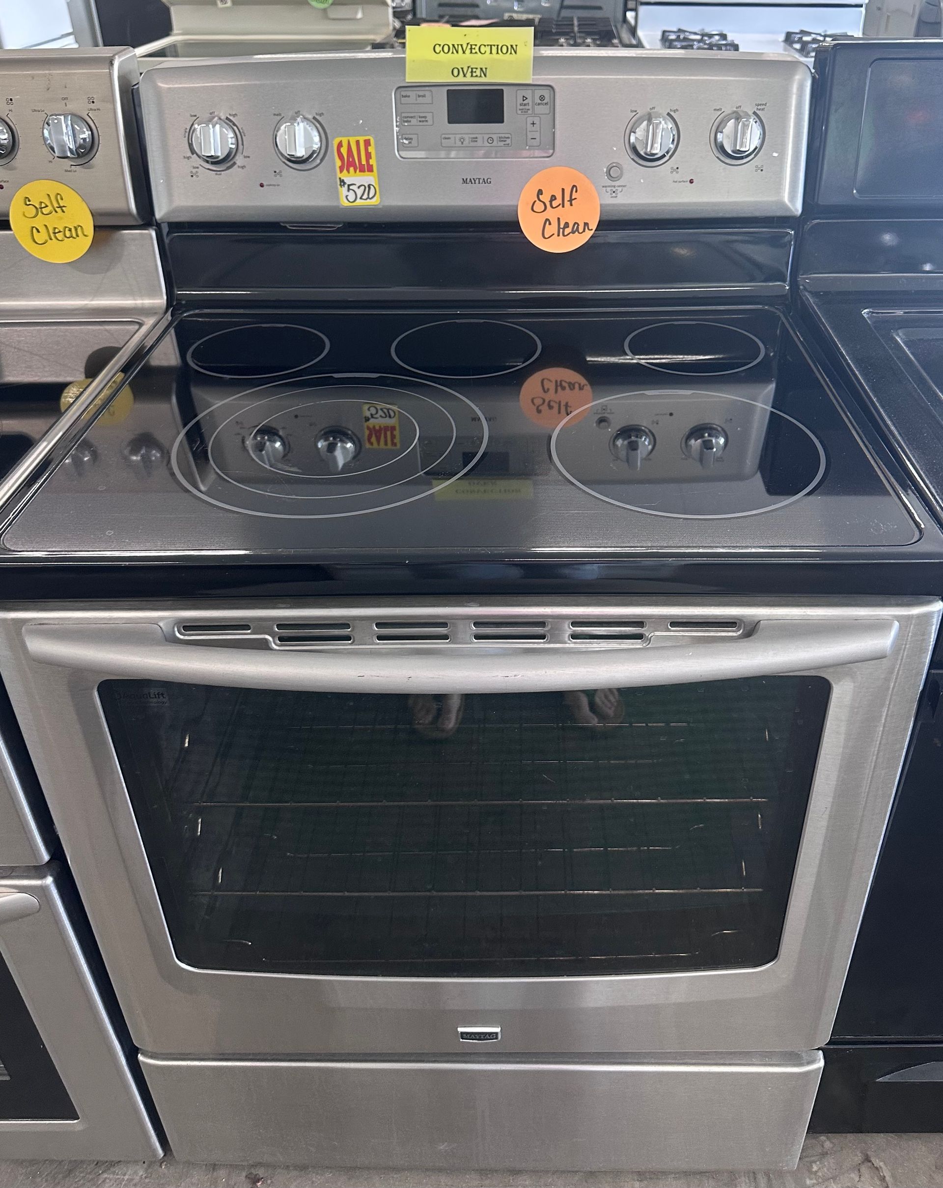 A stainless steel stove top oven with a yellow sign that says sell