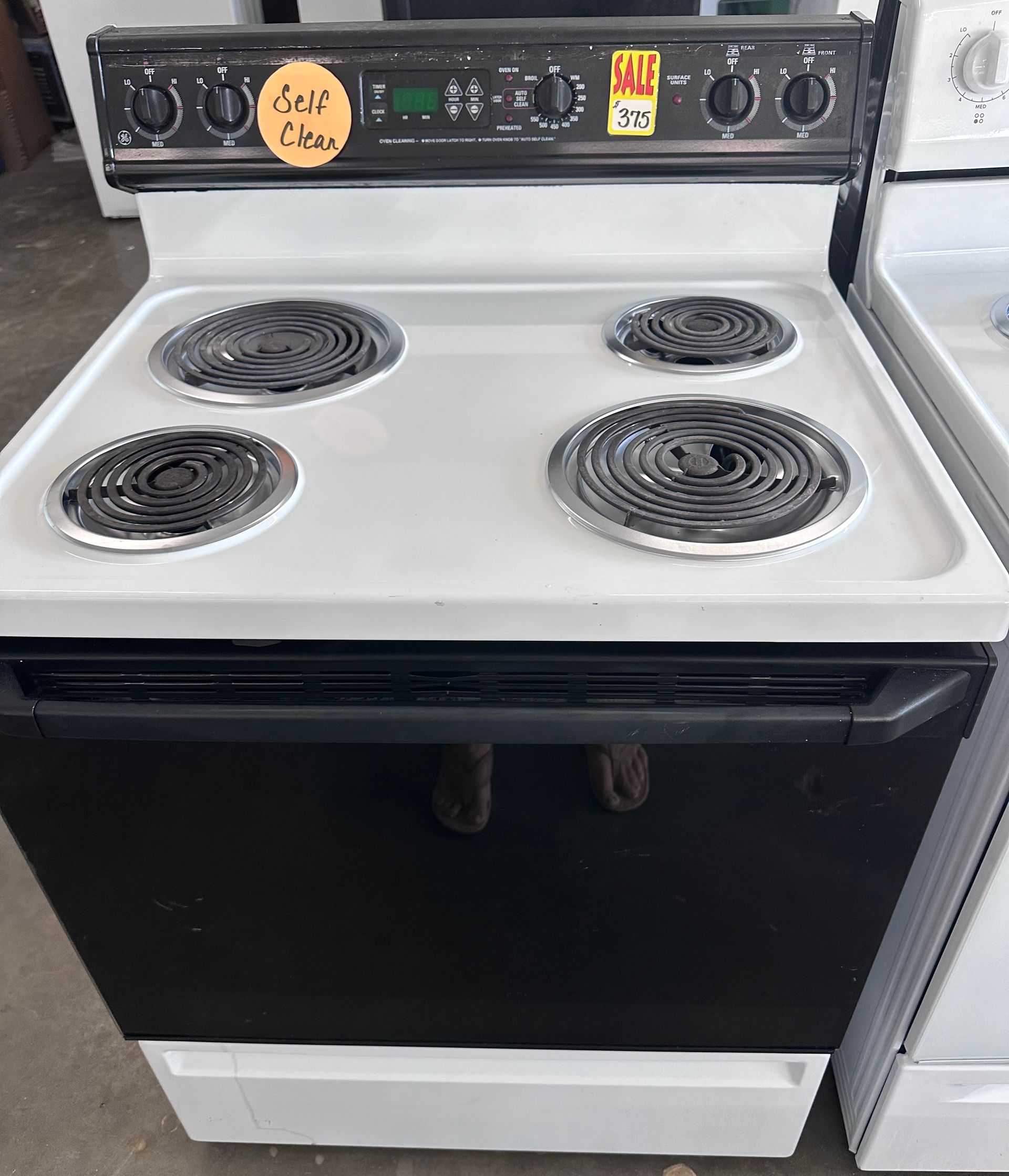 Black and white electric stove with four burners;