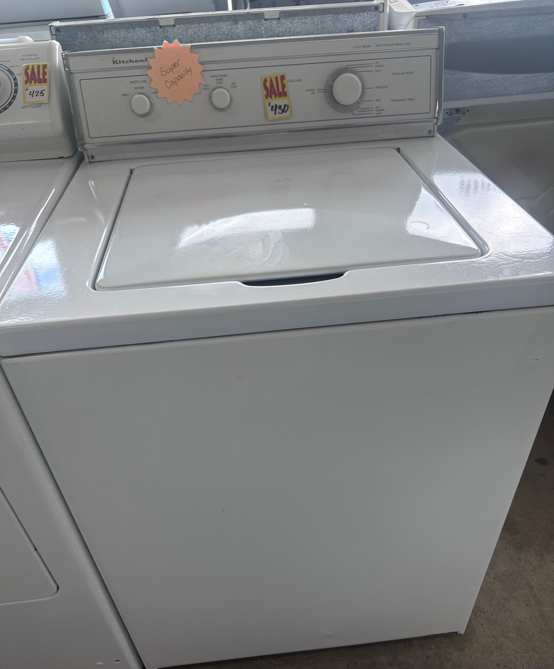White top-load washing machine with controls on the top.