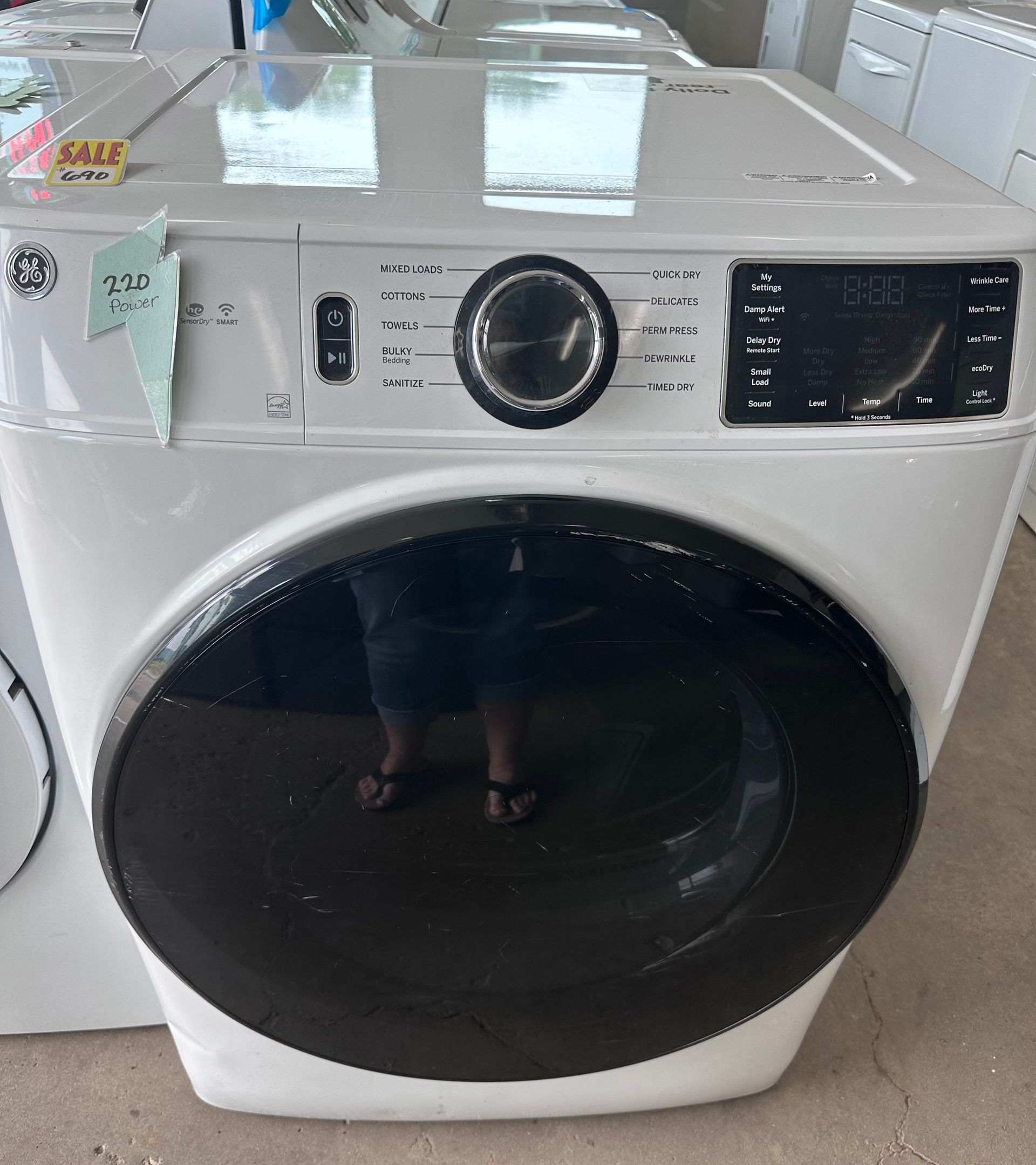 A white washing machine with a black door is sitting on the floor.