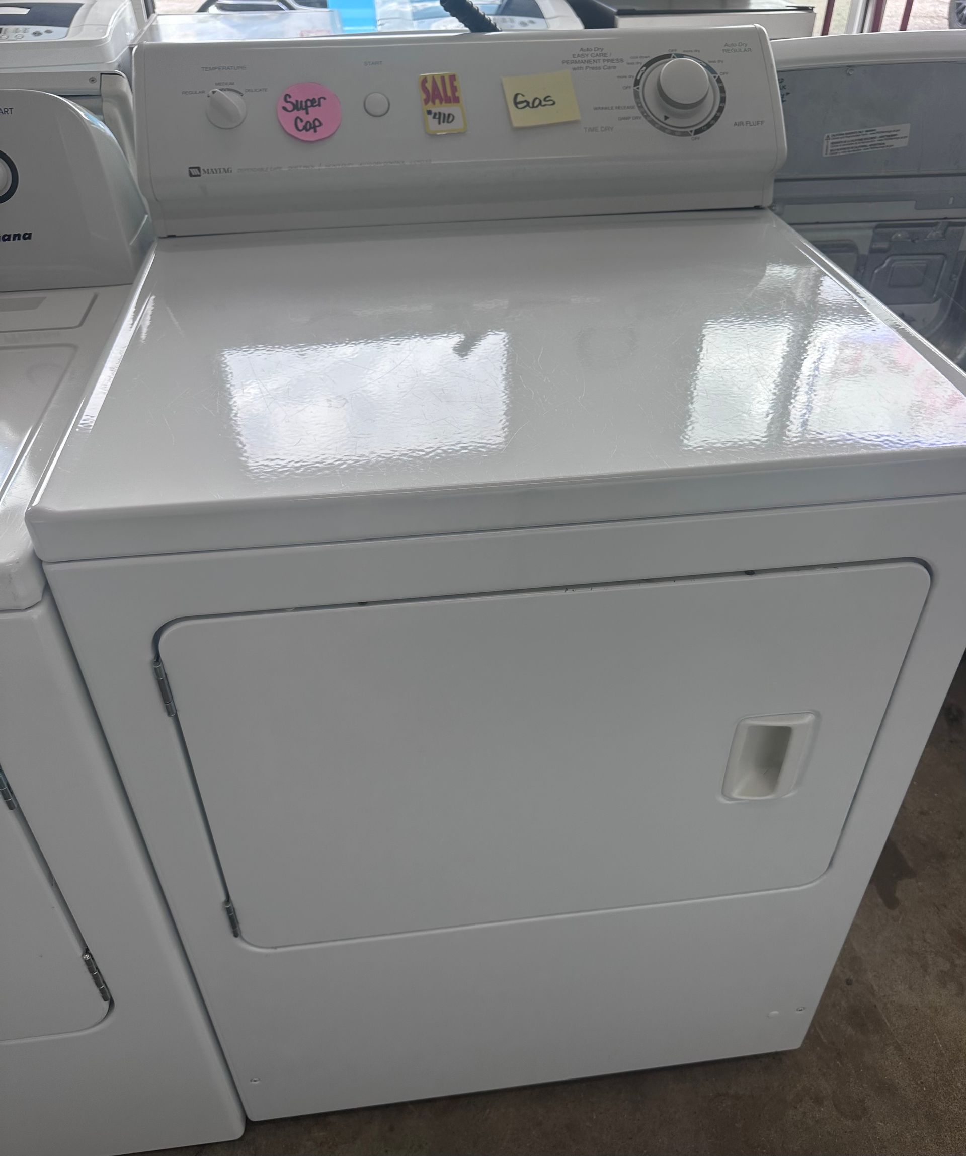 White electric clothes dryer with control panel on top.