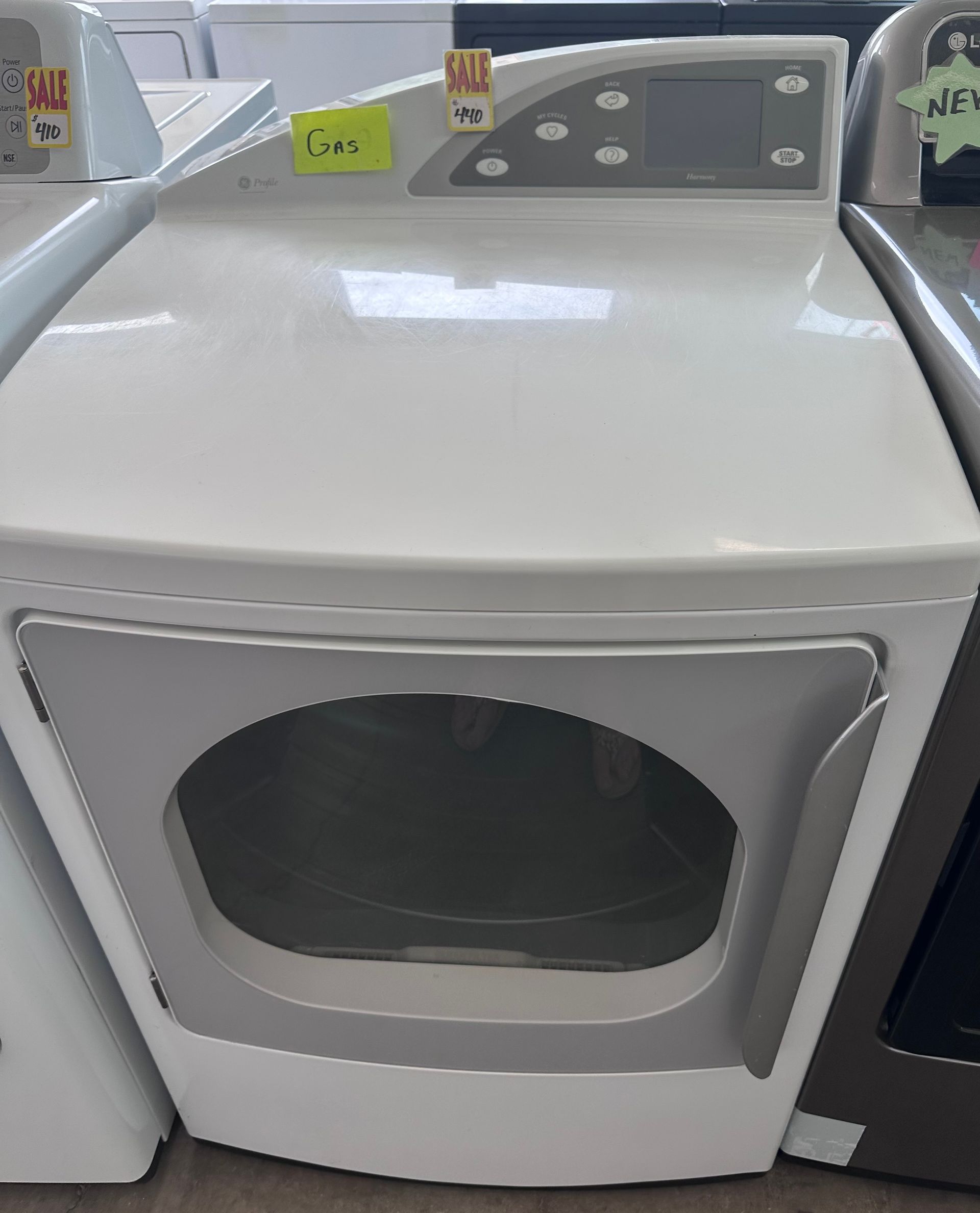 A white dryer is sitting in a row of other dryers.