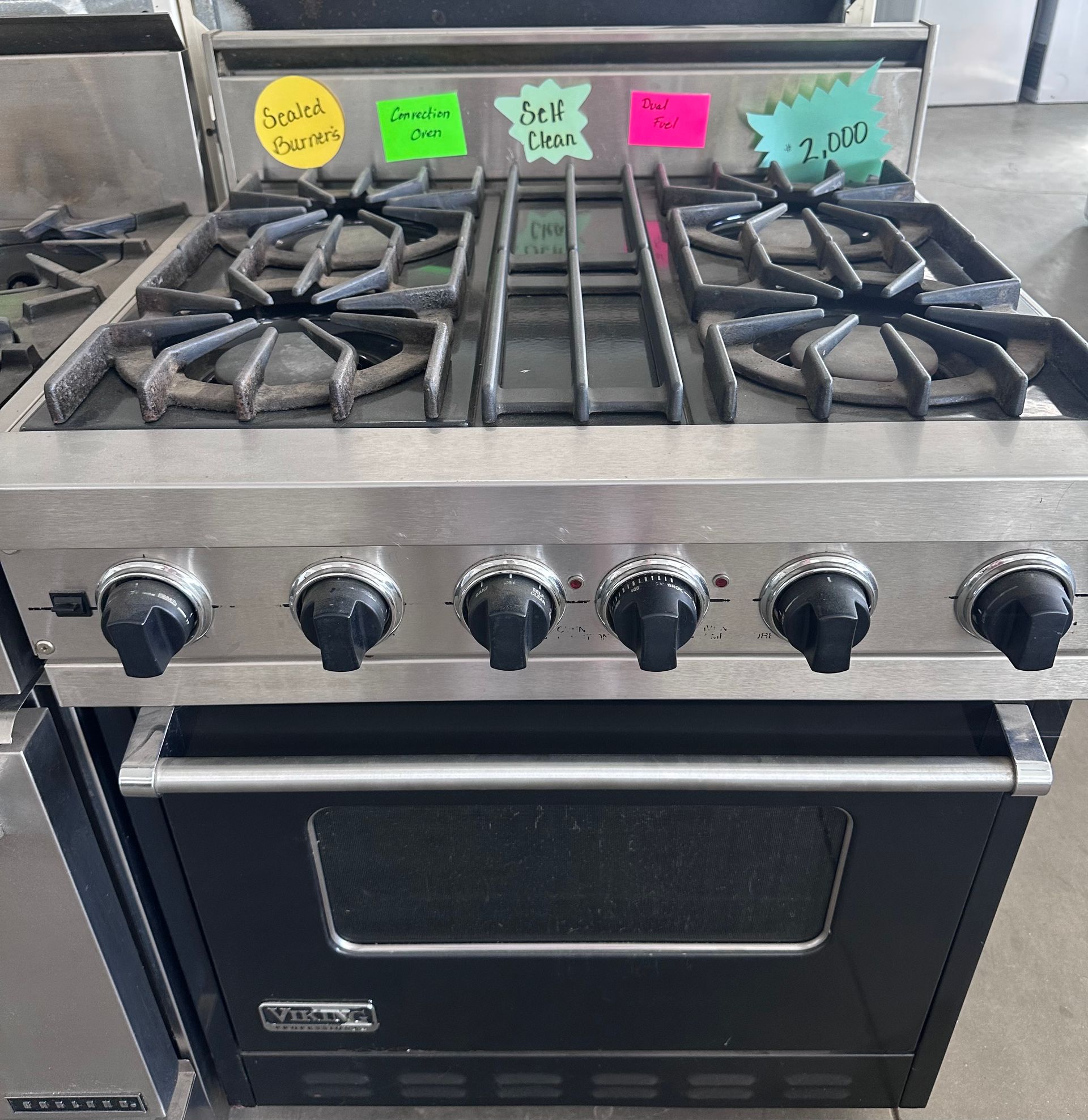 Stainless steel Viking range with six burners, oven, and labeled knobs.