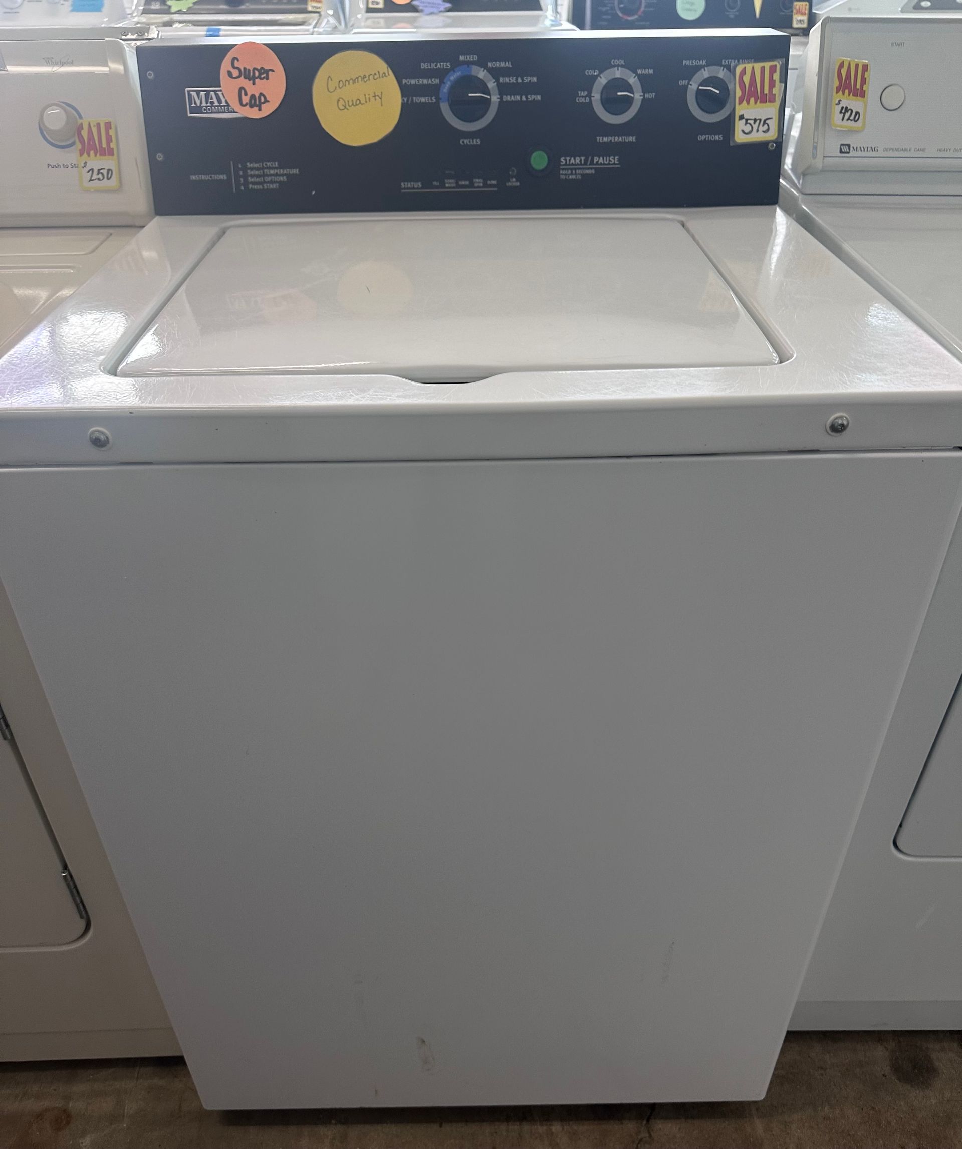 White top-load washing machine with black control panel.