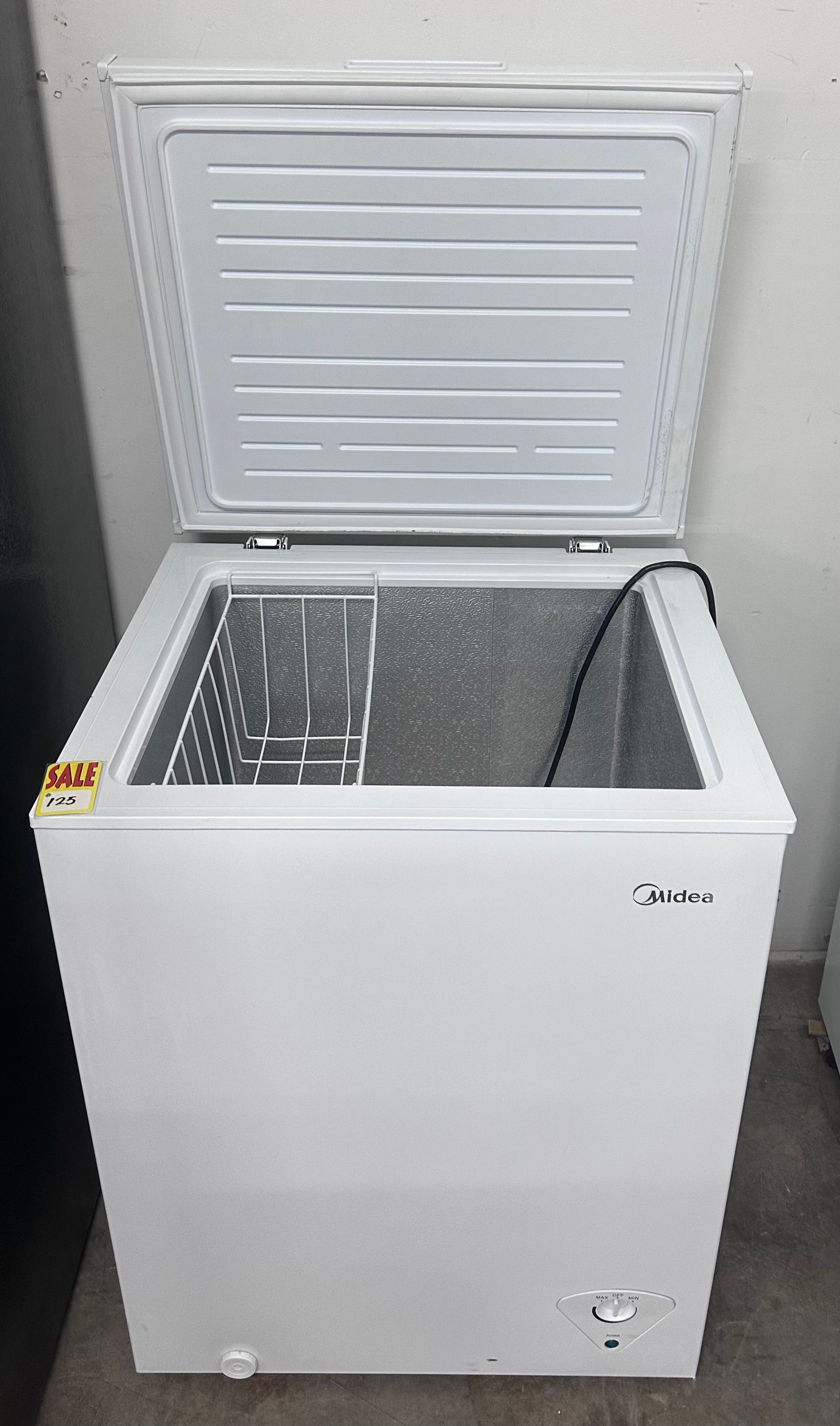 Open white chest freezer with lid raised, showing empty interior.