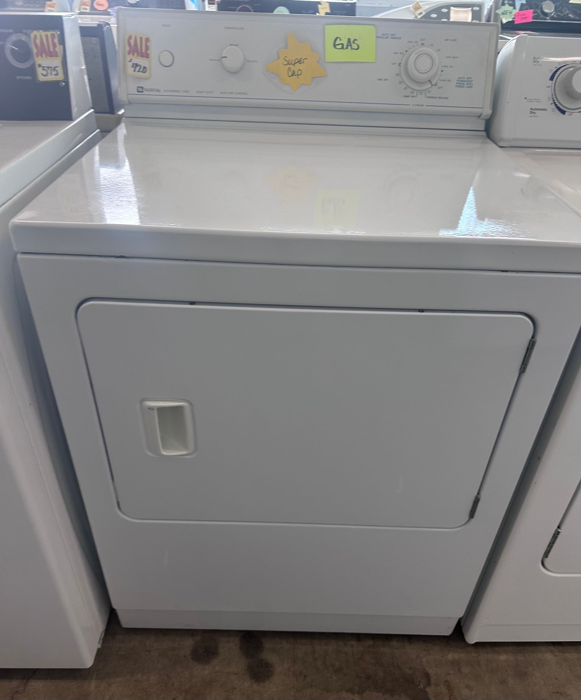 White electric dryer with controls on top, door handle on the front.