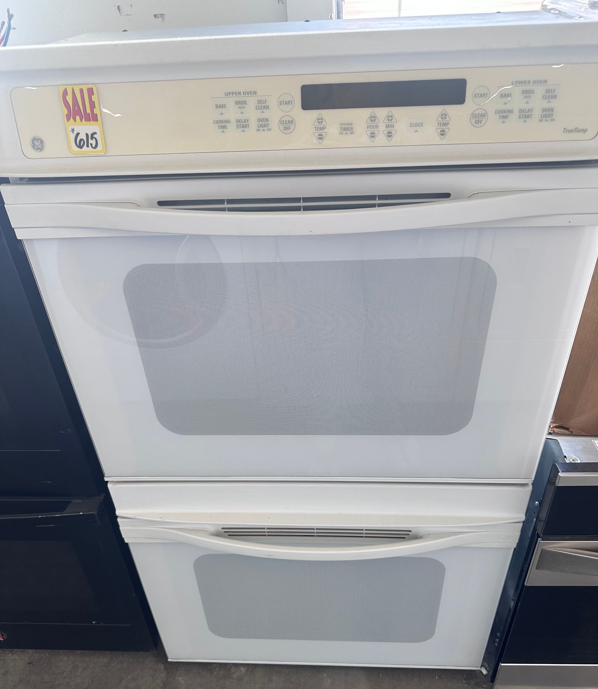 A white double oven is sitting on top of a counter.