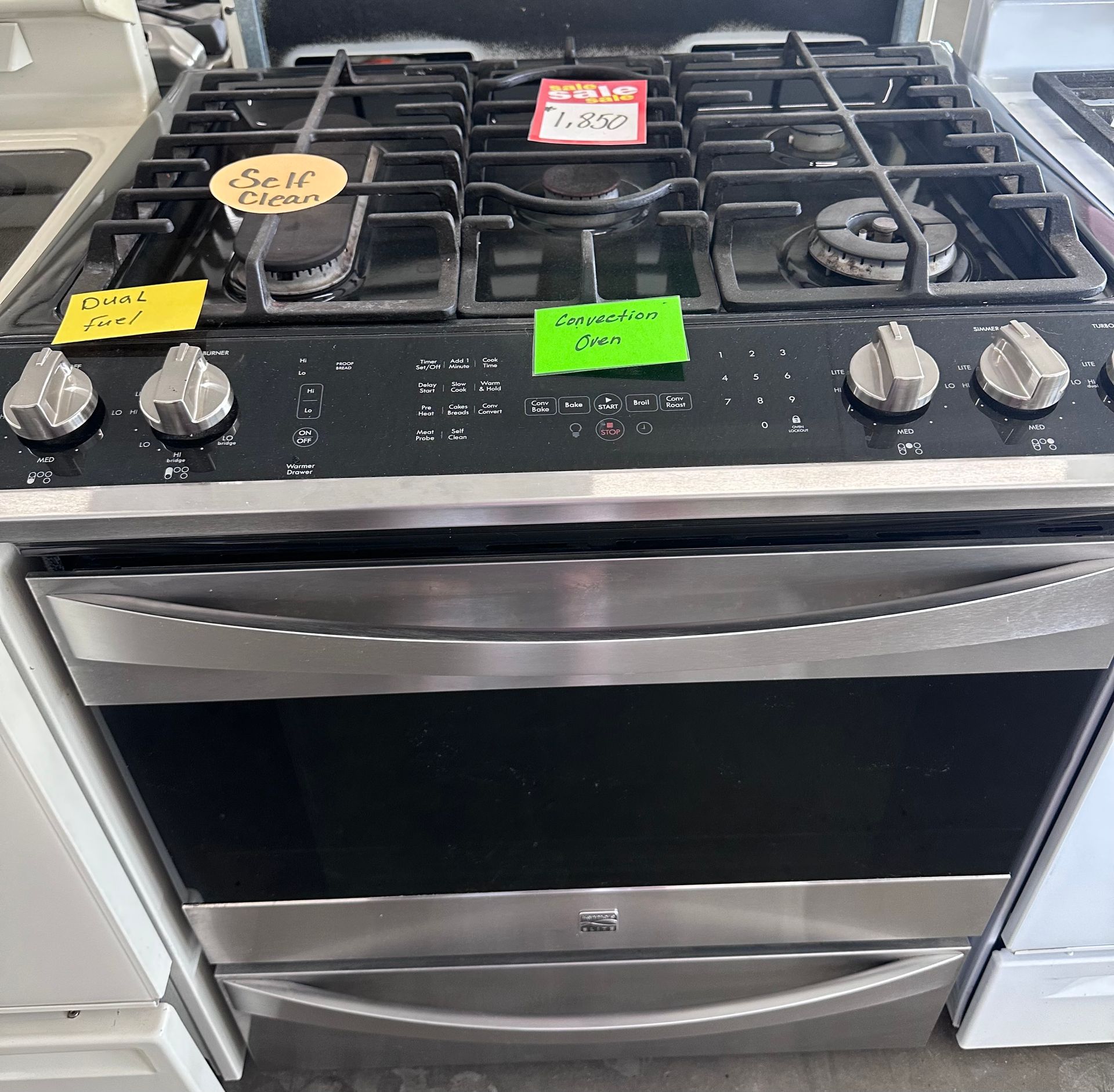 Stainless steel gas range with six burners and an oven.