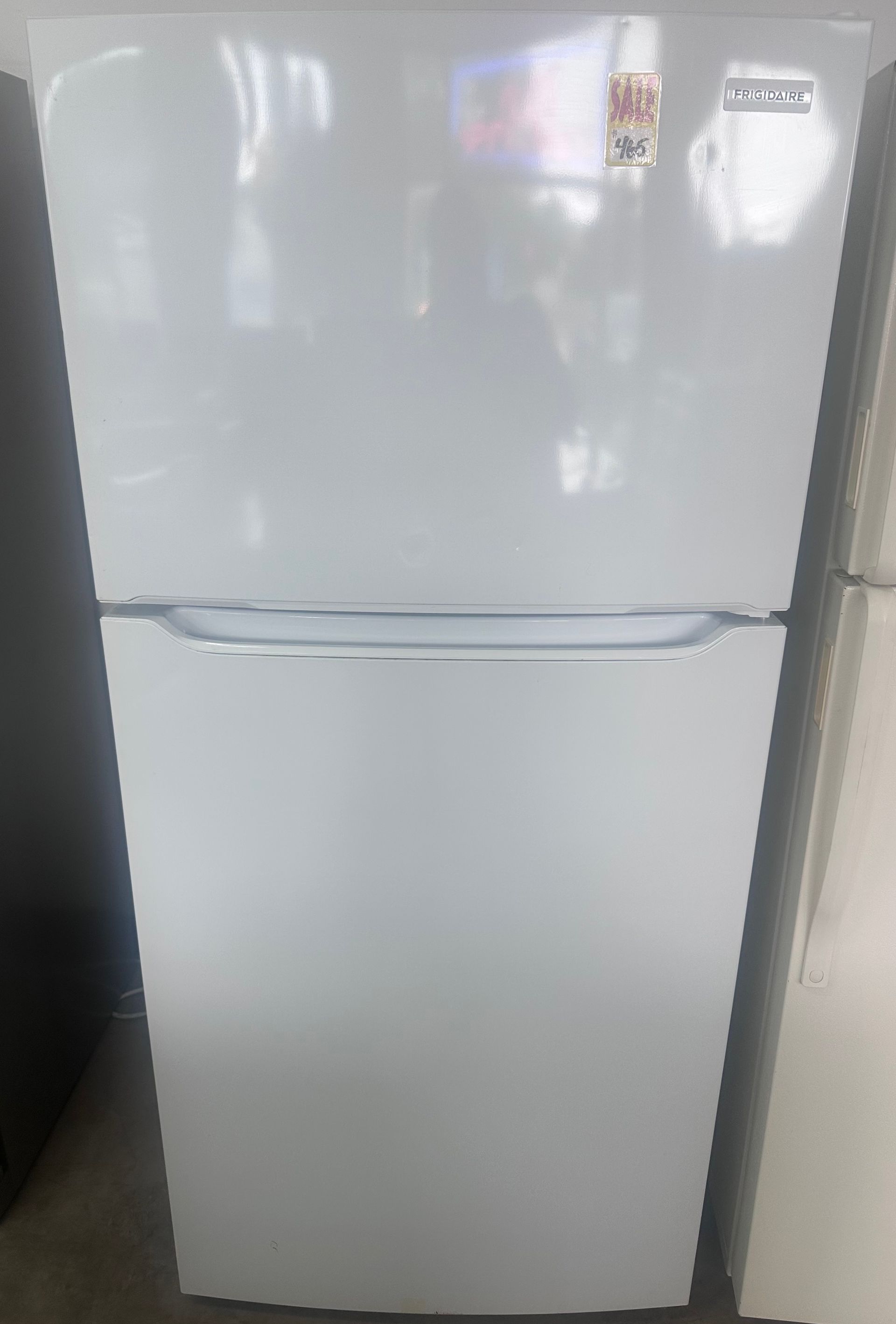 Stainless steel side-by-side refrigerator with sale stickers.