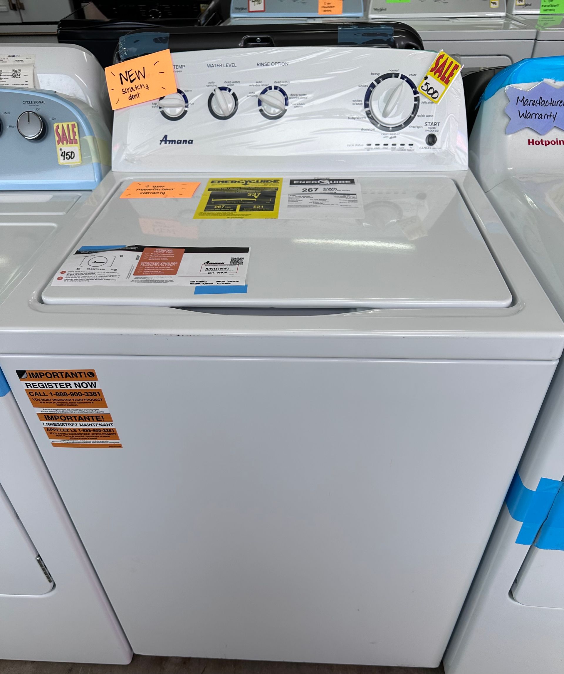 A white washer and dryer are sitting on a wooden floor.