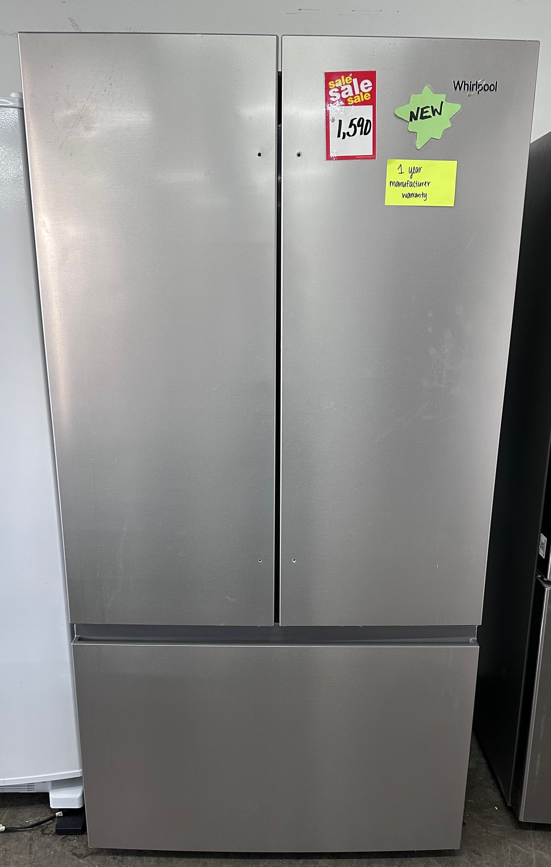A silver, French-door refrigerator with a bottom freezer drawer, featuring sale tags on the front.