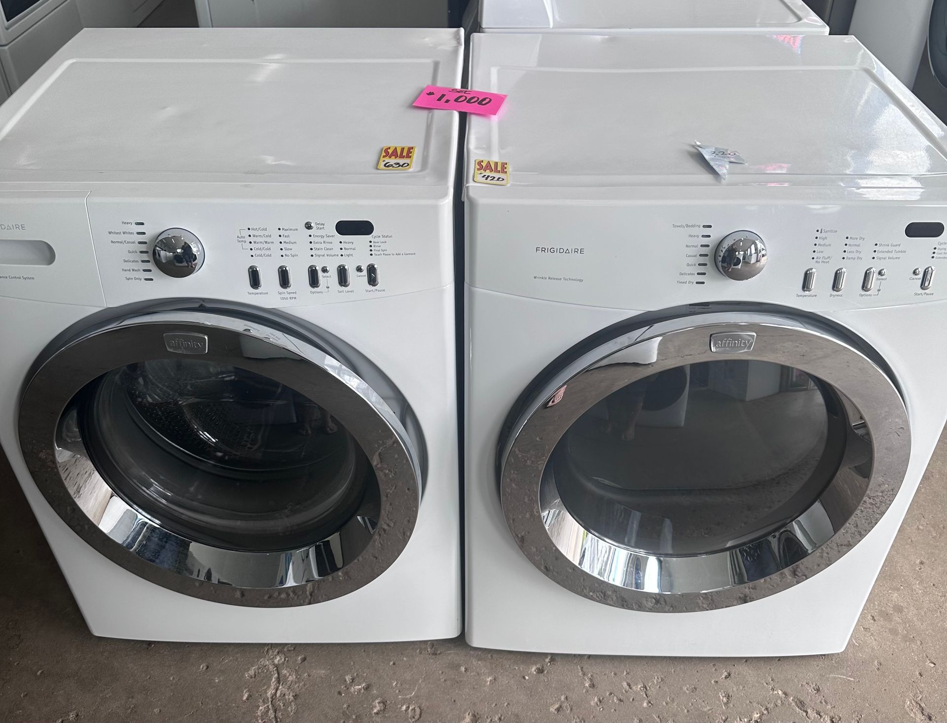 Two white front-load washing machines with silver trim and control panels.