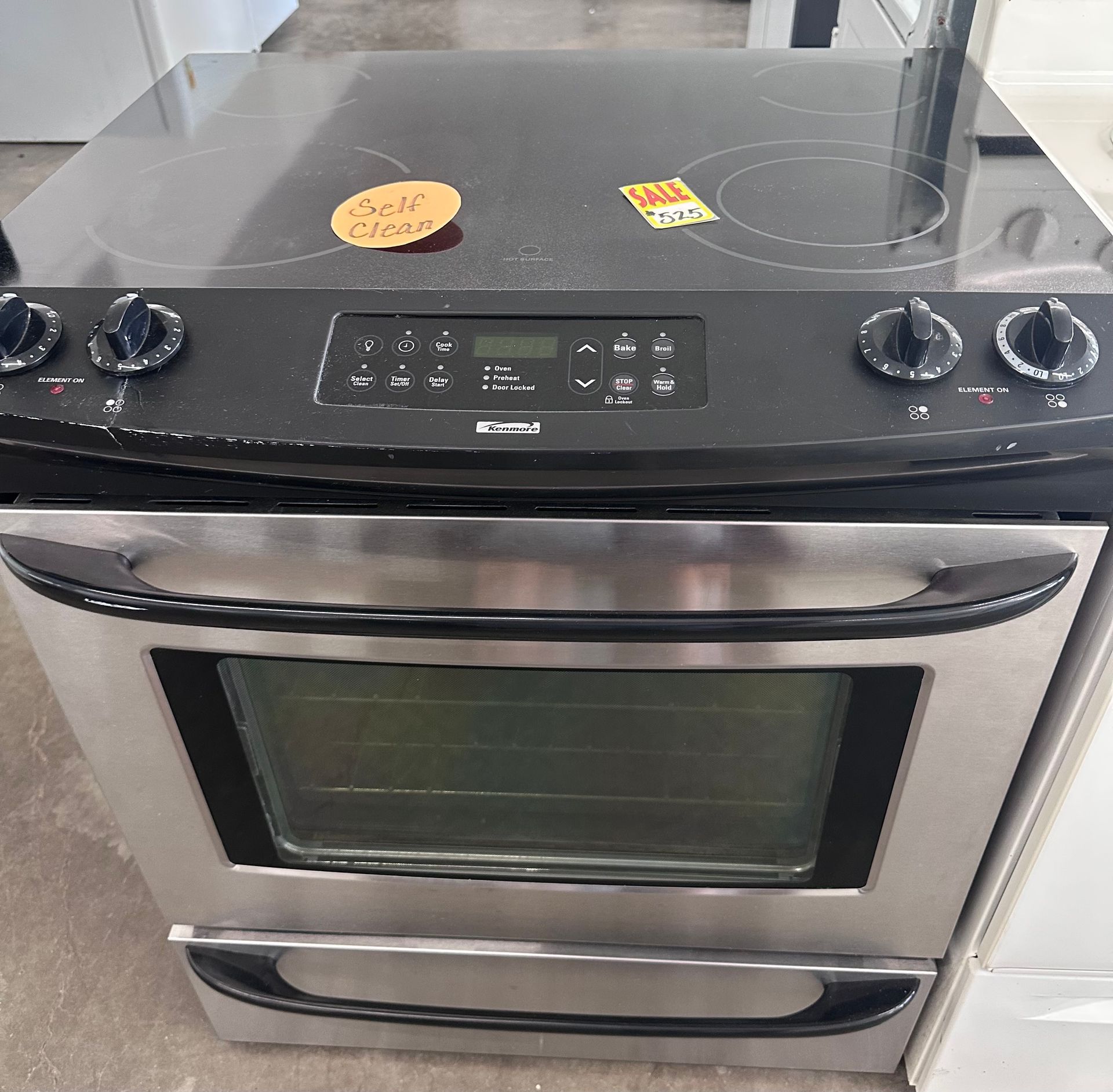 Stainless steel electric range with black cooktop and control panel.