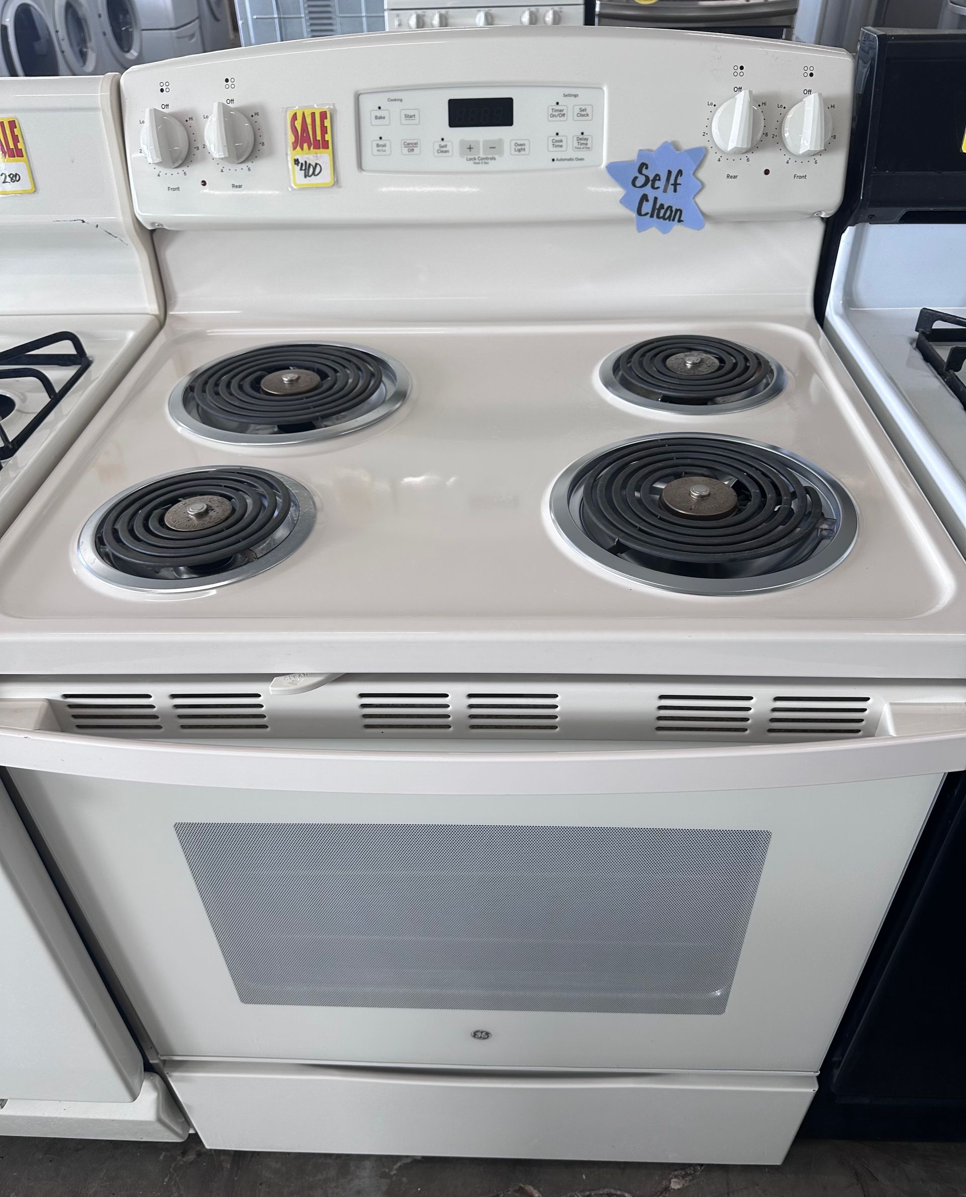 White electric stove with four burners and a front oven door.