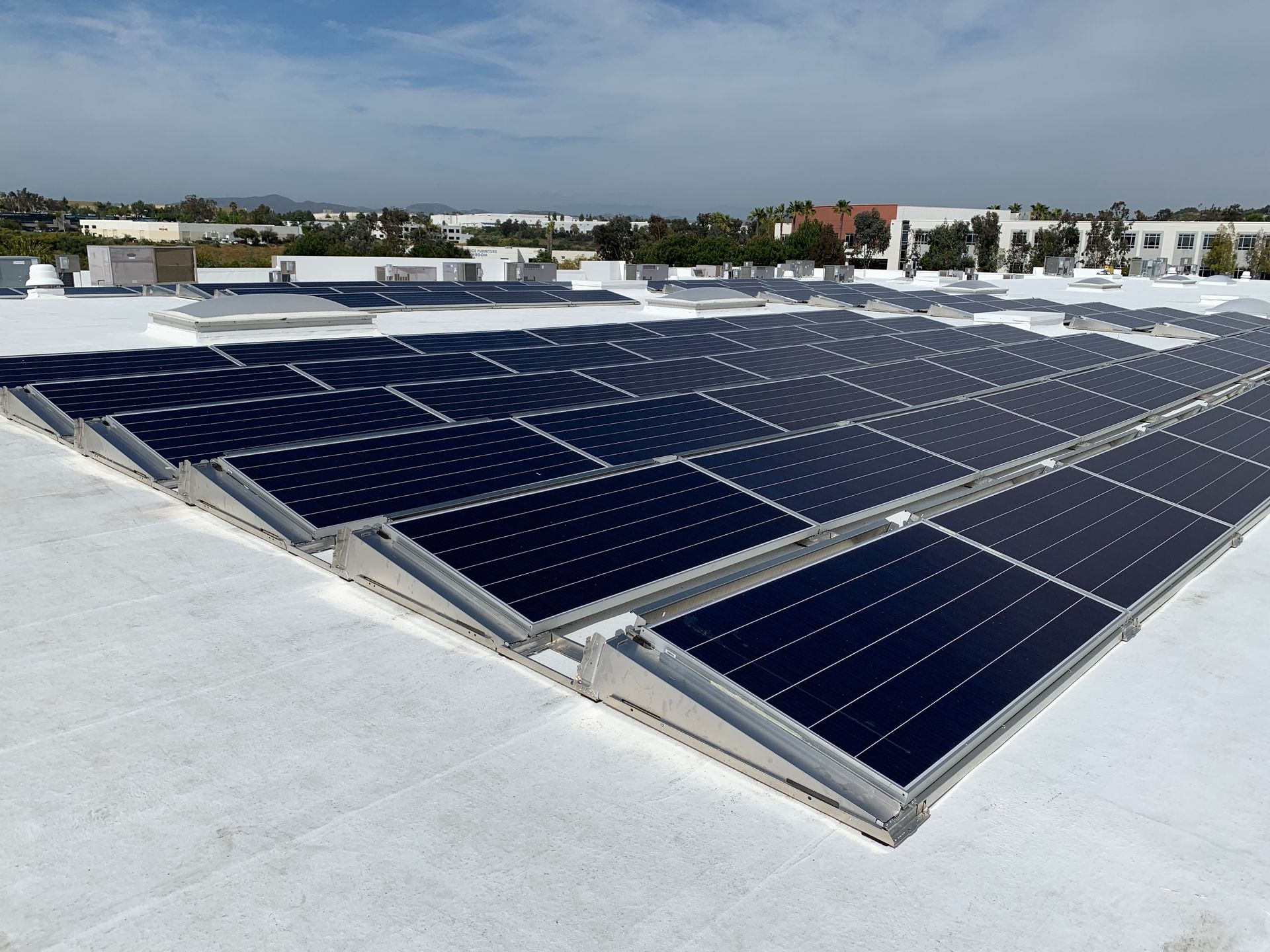 A row of solar panels on a white roof