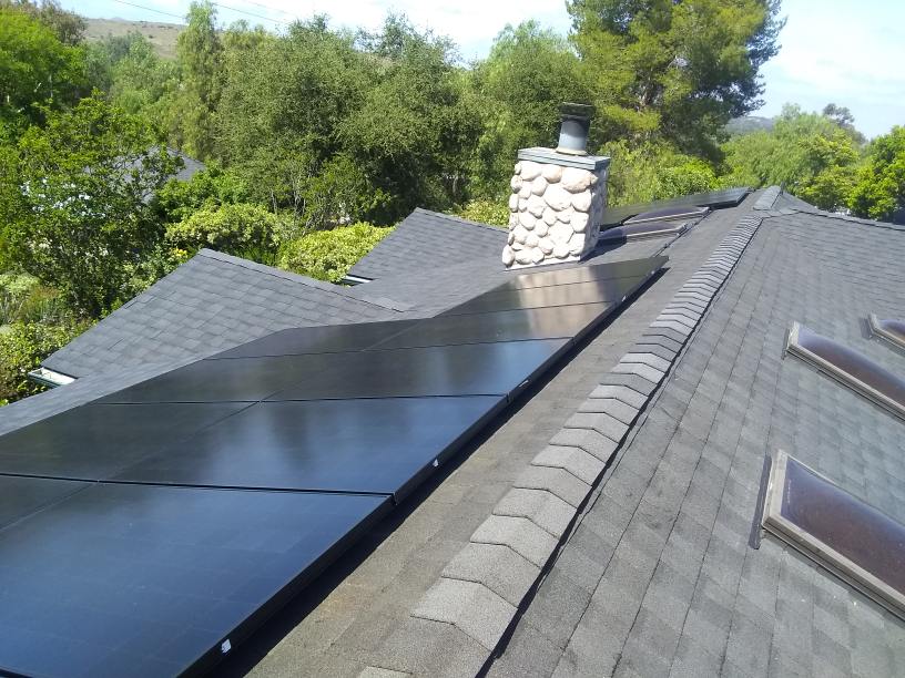 A roof with a chimney and solar panels on it