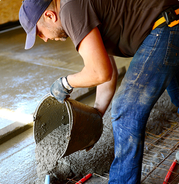 A man is pouring concrete into a bucket
